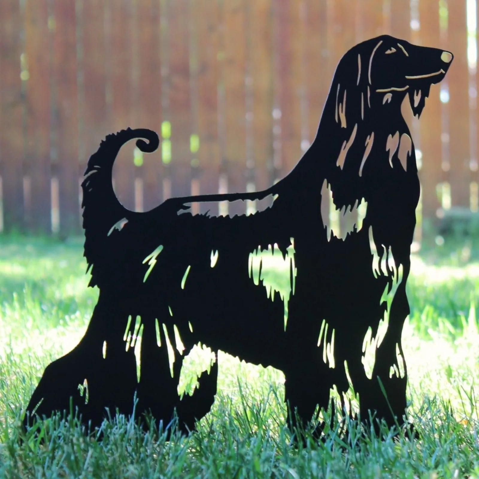 Black Afghan Hound metal silhouette standing in green grass, showcasing intricate cutouts and a sleek design.