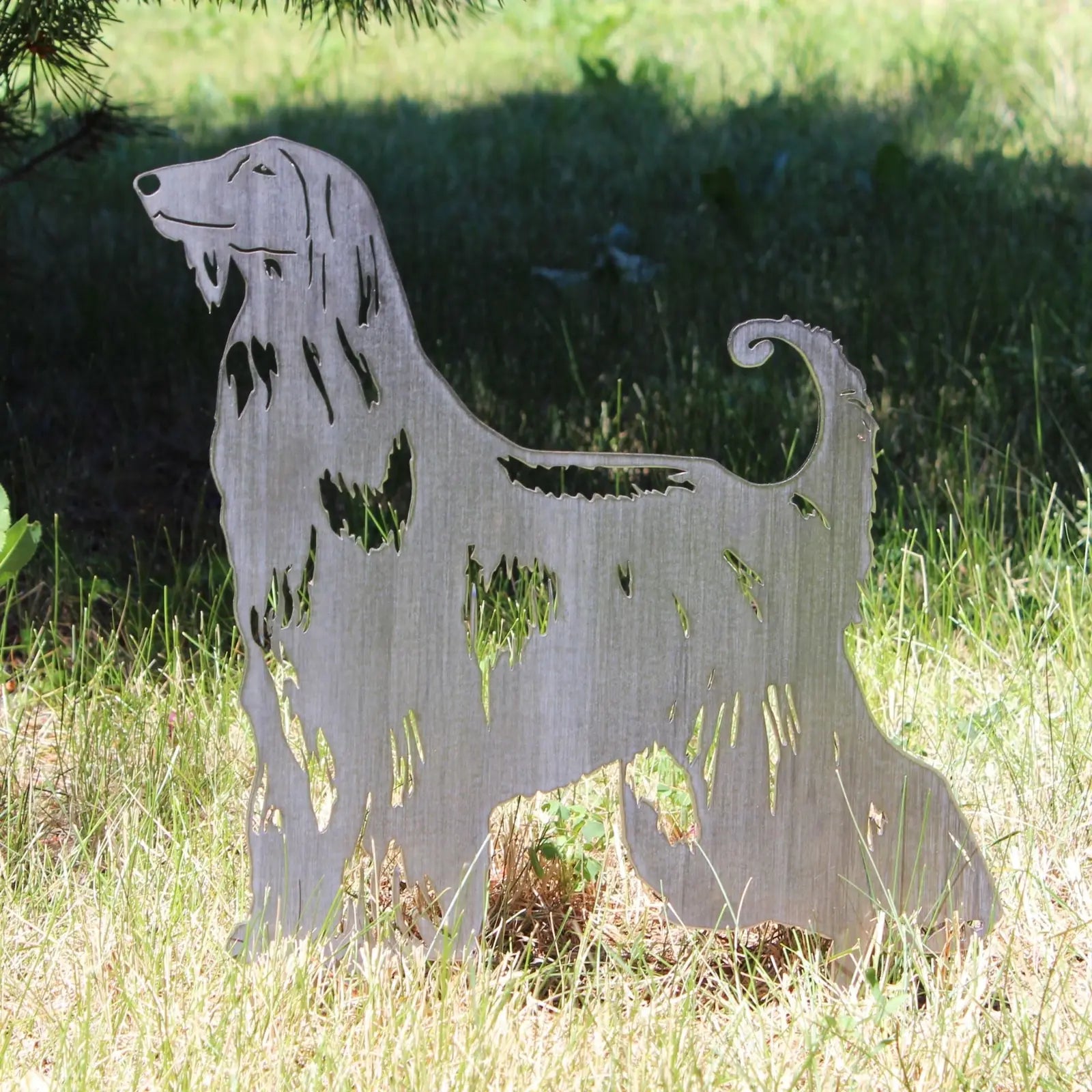 Afghan Hound metal silhouette in natural Corten steel, standing on grass, showcasing intricate cutout design.