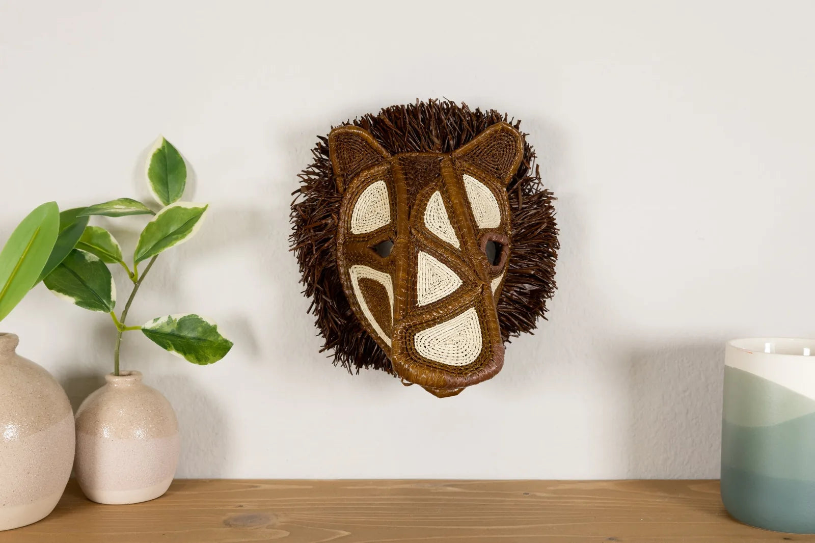 Handwoven African Wild Dog mask featuring brown, cream, and natural textures, enhancing wall decor with vibrant artistry.
