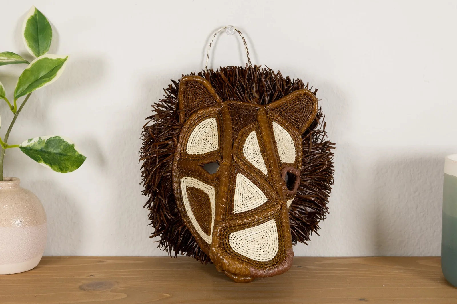 Handwoven African Wild Dog mask featuring intricate brown and beige patterns, crafted from natural materials.