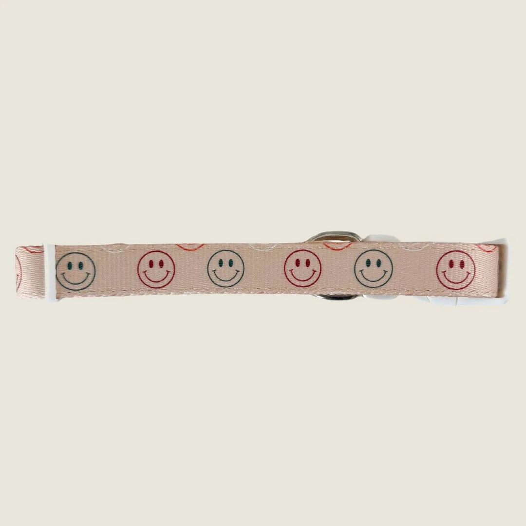 Cheerful beige dog collar with smiley face pattern, made from soft polyester webbing and neoprene padding.