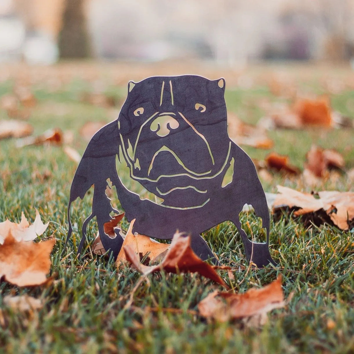 American Bully silhouette in Corten steel, displayed on grass with autumn leaves. Perfect for dog breed metal art.