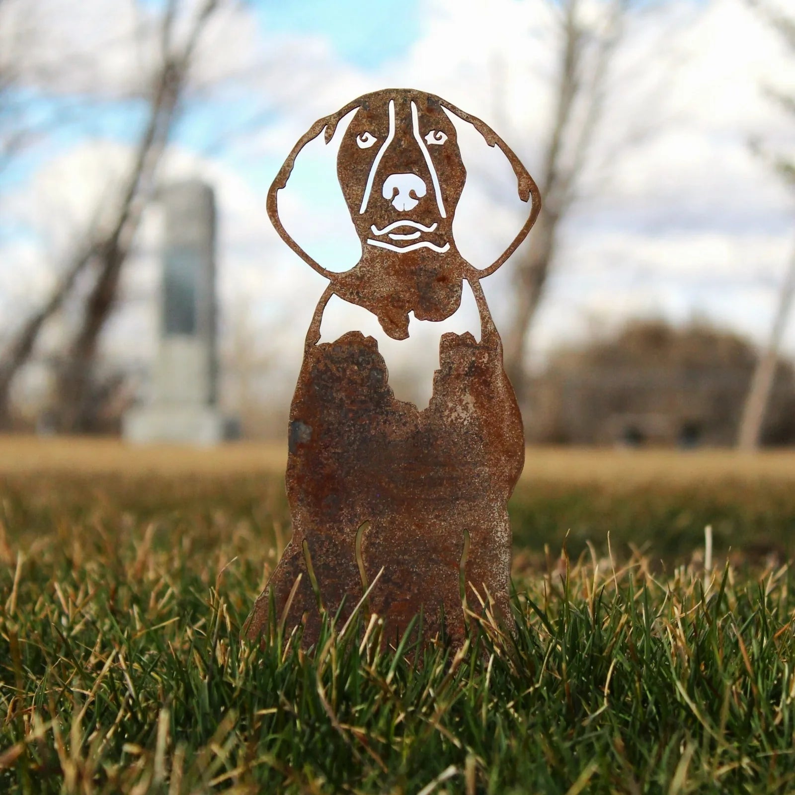 American English Coonhound metal silhouette in weathered Corten steel, displayed in grass against a blurred background.
