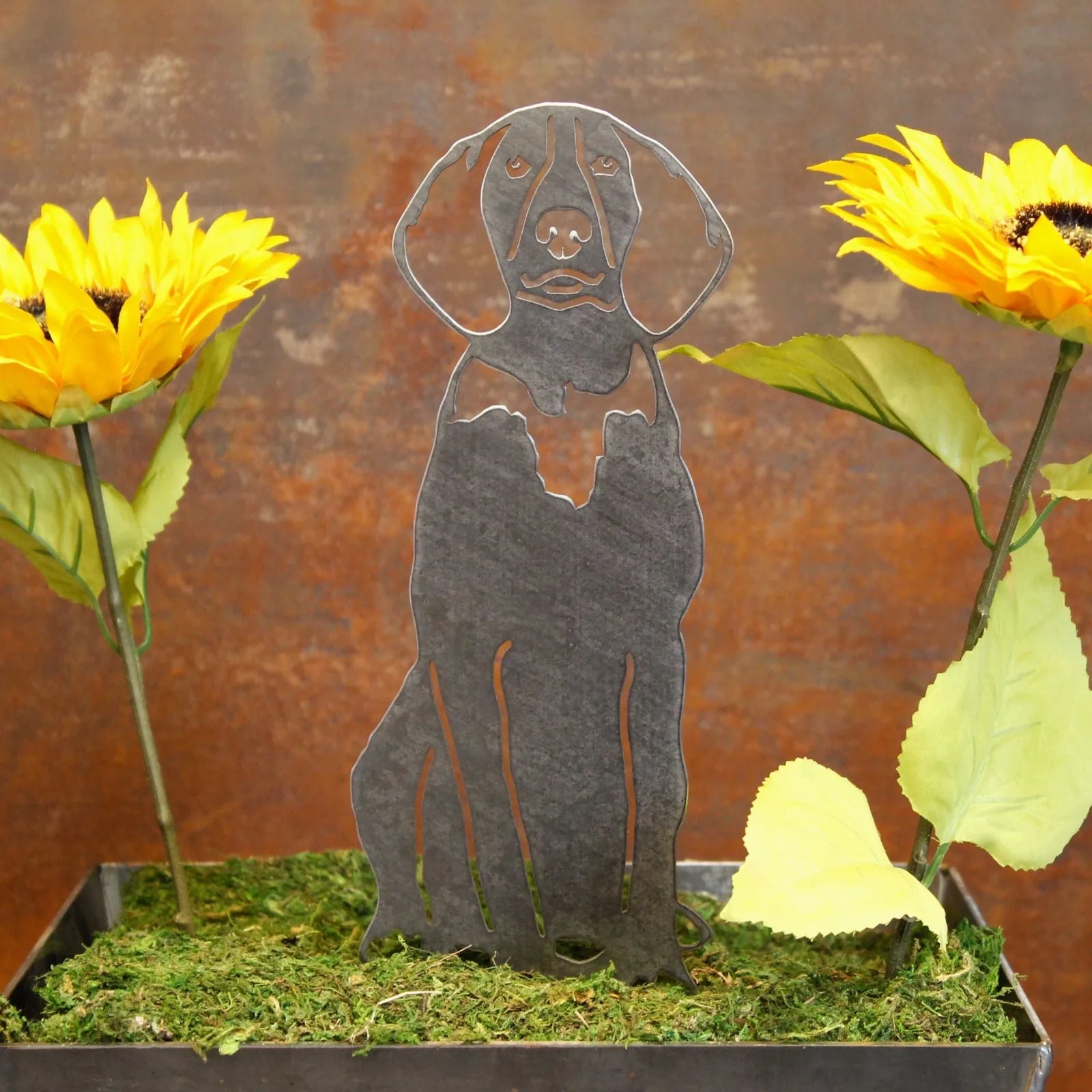 American English Coonhound metal silhouette in matte black, surrounded by sunflowers and green foliage.
