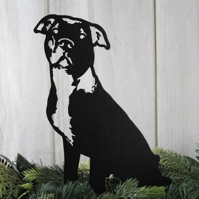 Black metal silhouette of an American Pit Bull Terrier, detailed features visible, surrounded by greenery.