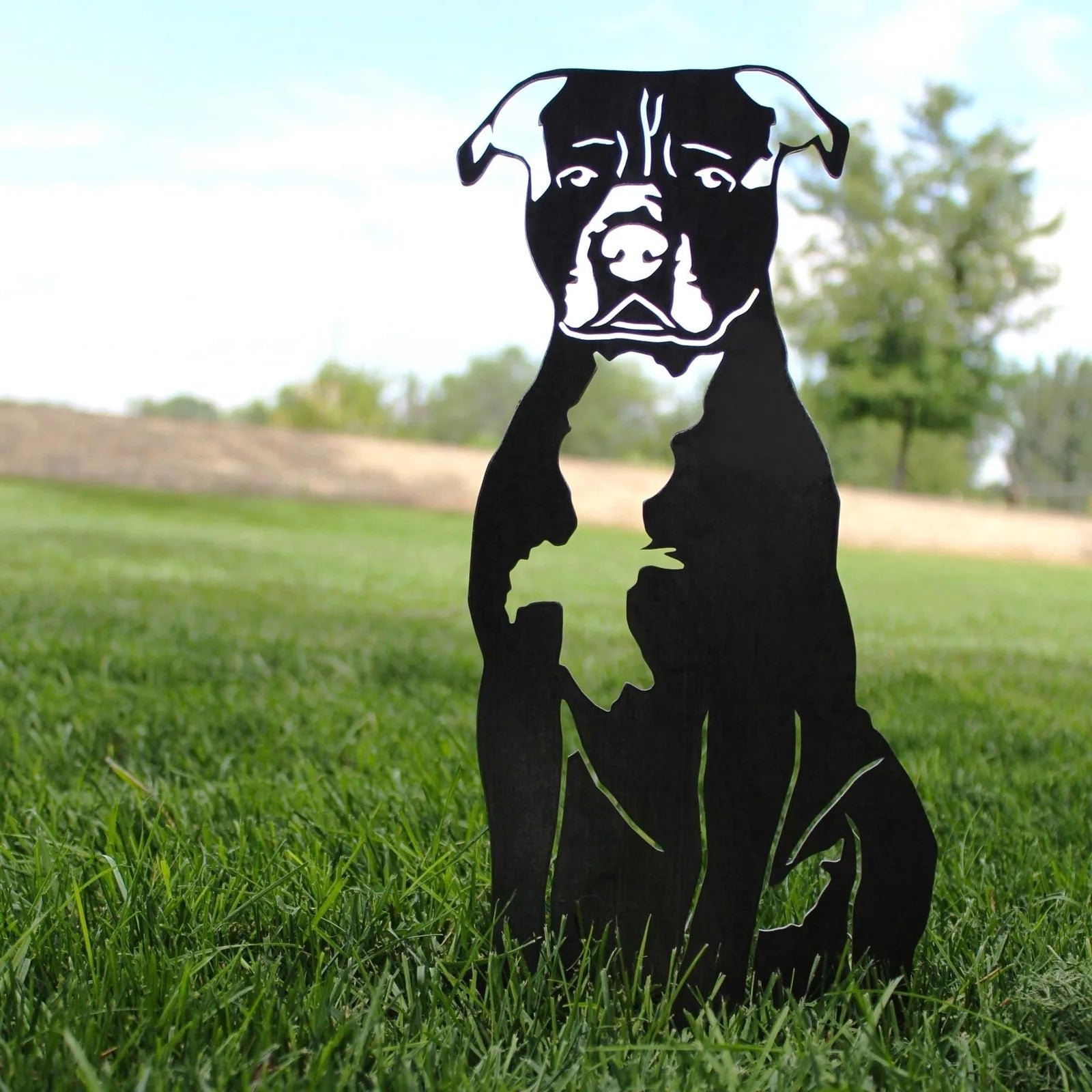 Handcrafted black metal silhouette of an American Staffordshire Terrier sitting in grass, designed for indoor or outdoor d...