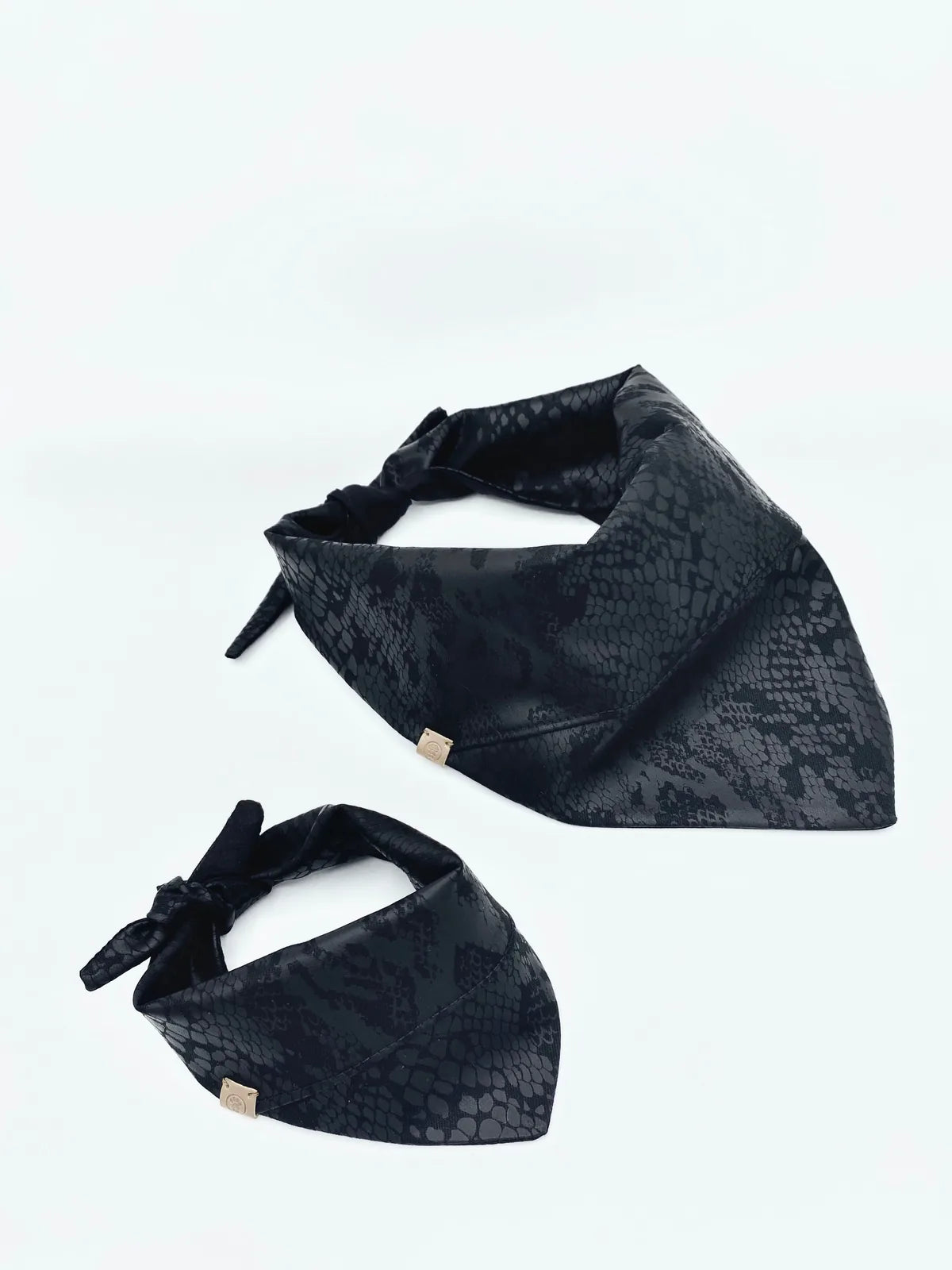 Reversible black bandanas with subtle snake print patterns, designed for pets, in XS/S and M/L sizes.