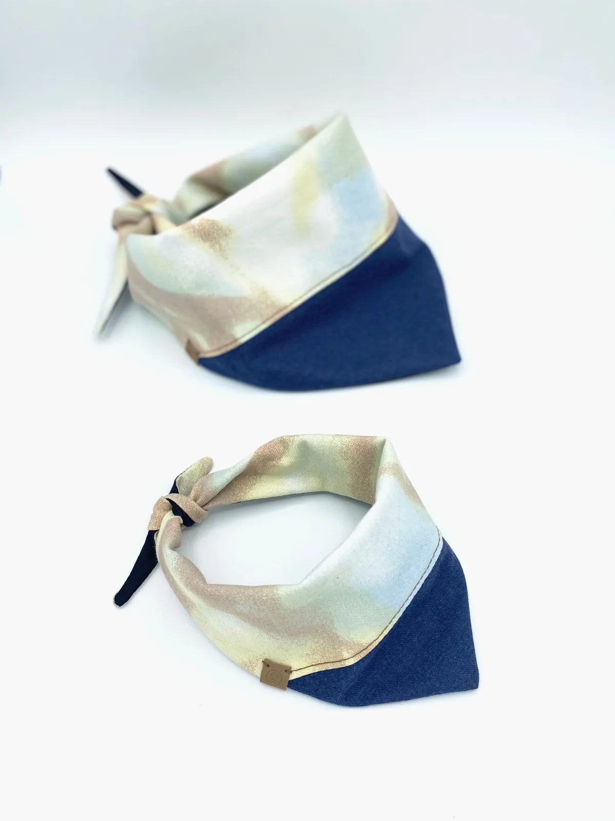 Reversible pet bandana in soft cotton, featuring a light watercolor pattern on one side and a solid navy on the other.