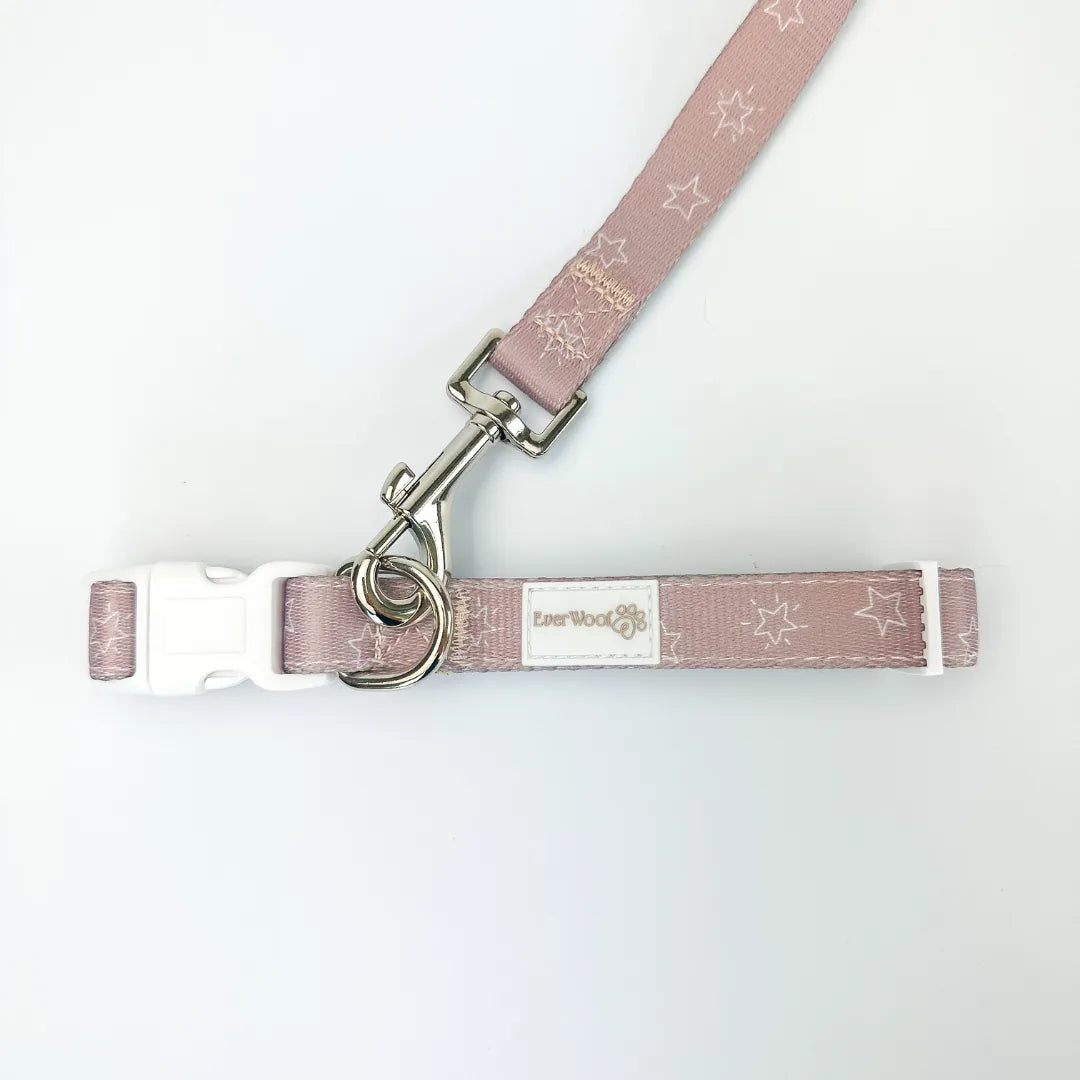 A soft pink dog leash with star pattern, featuring a zinc alloy hook and an adjustable clip for essentials.