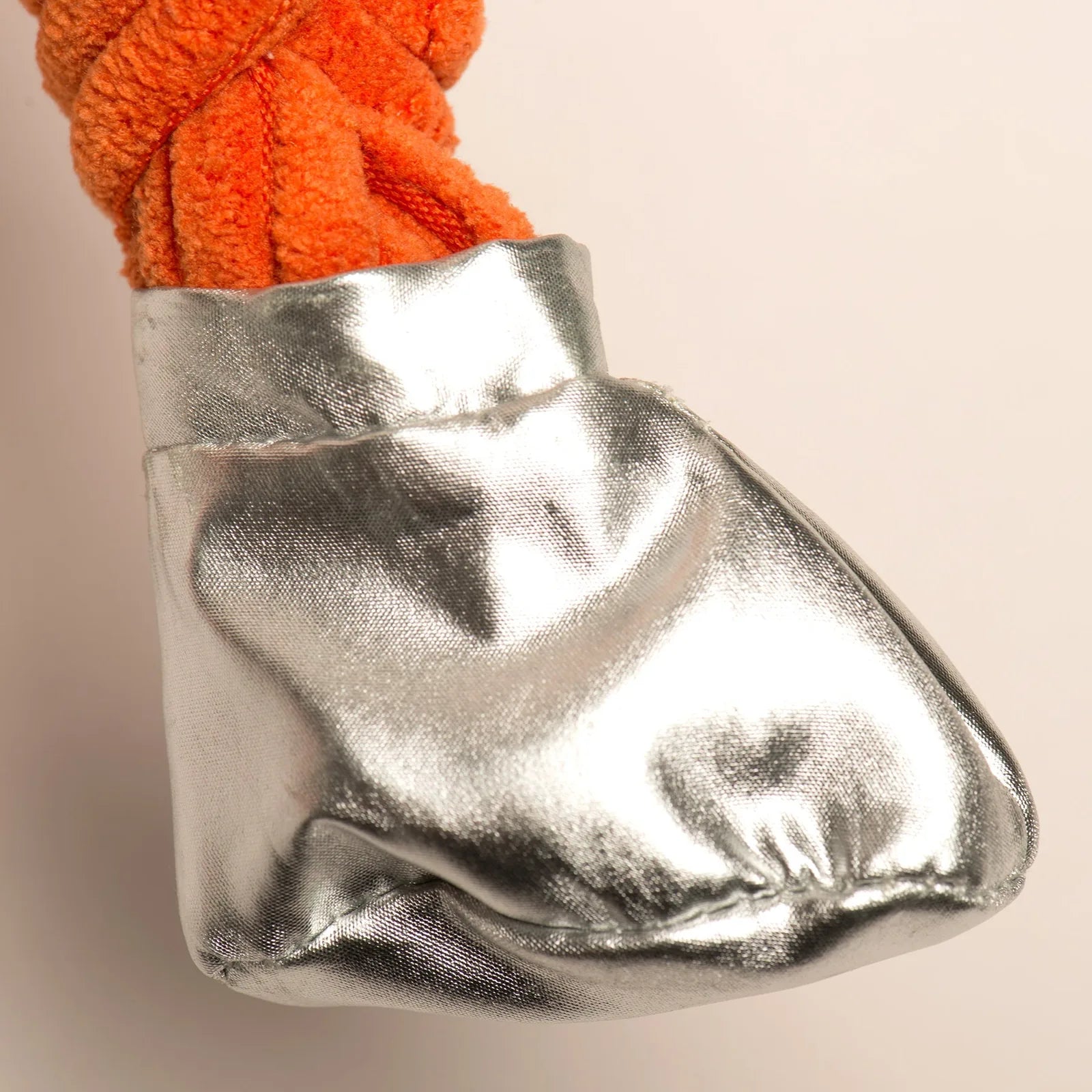 Bright orange plush fabric with a shiny silver boot, part of the Astro-Knottie® dog toy design.