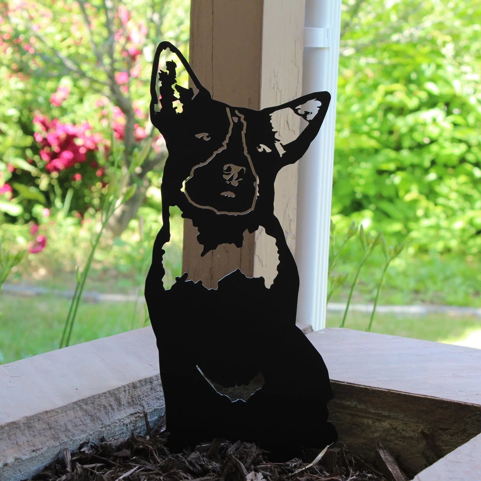 Black metal silhouette of an Australian Cattle Dog with a natural outdoor background, perfect for dog-themed decor.