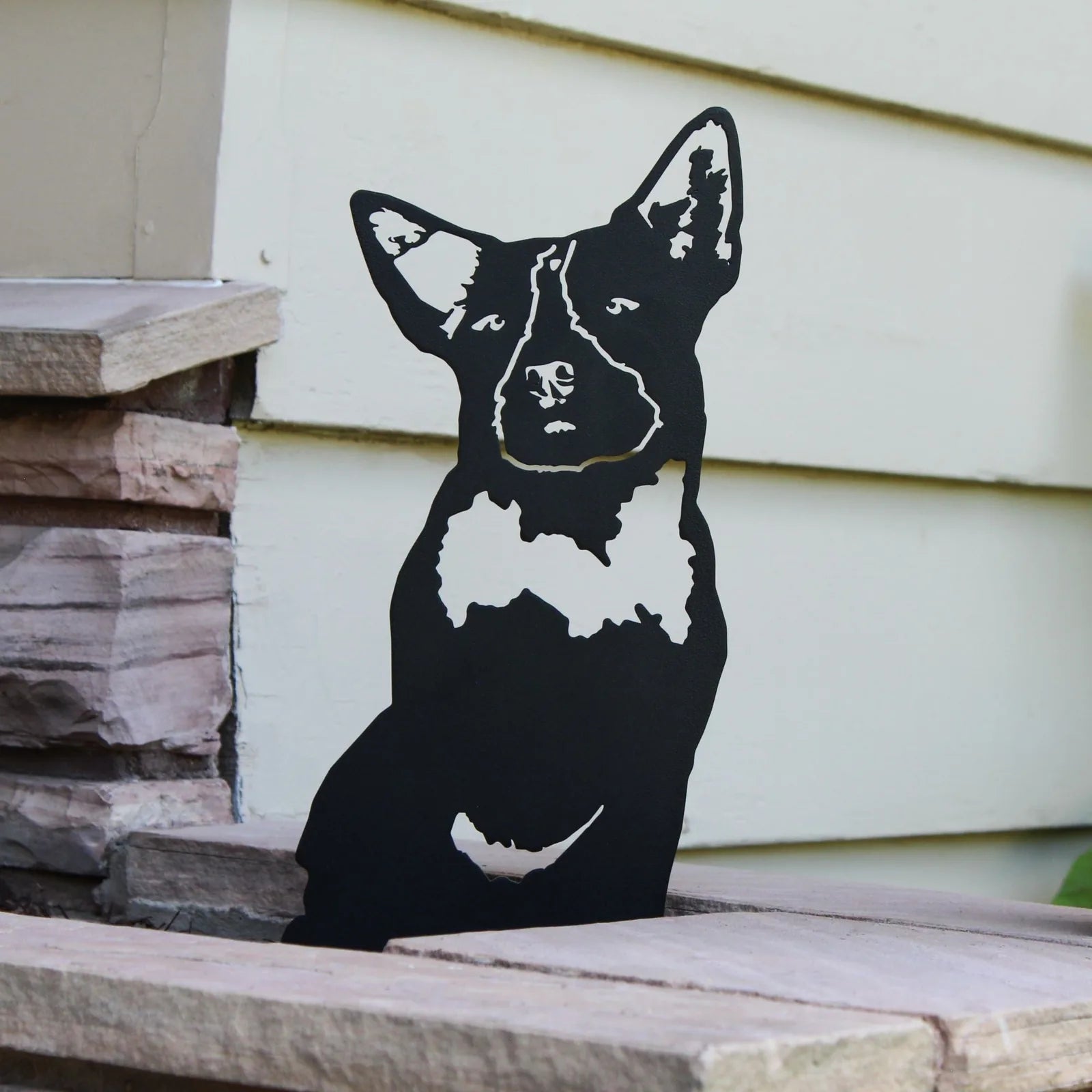 Black metal silhouette of an Australian Cattle Dog, showcasing detailed facial features, set against a light background.