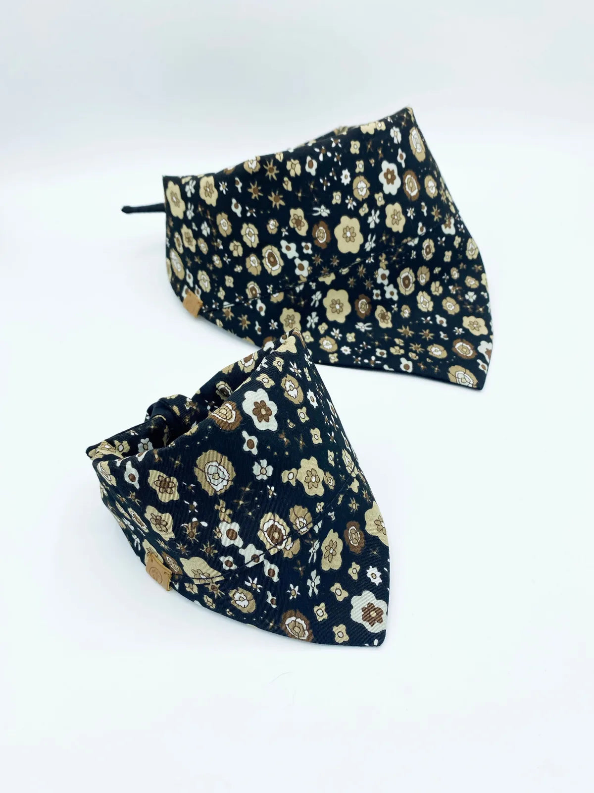 Reversible black pet bandanas with floral patterns in cream and brown, crafted from soft cotton for comfort.