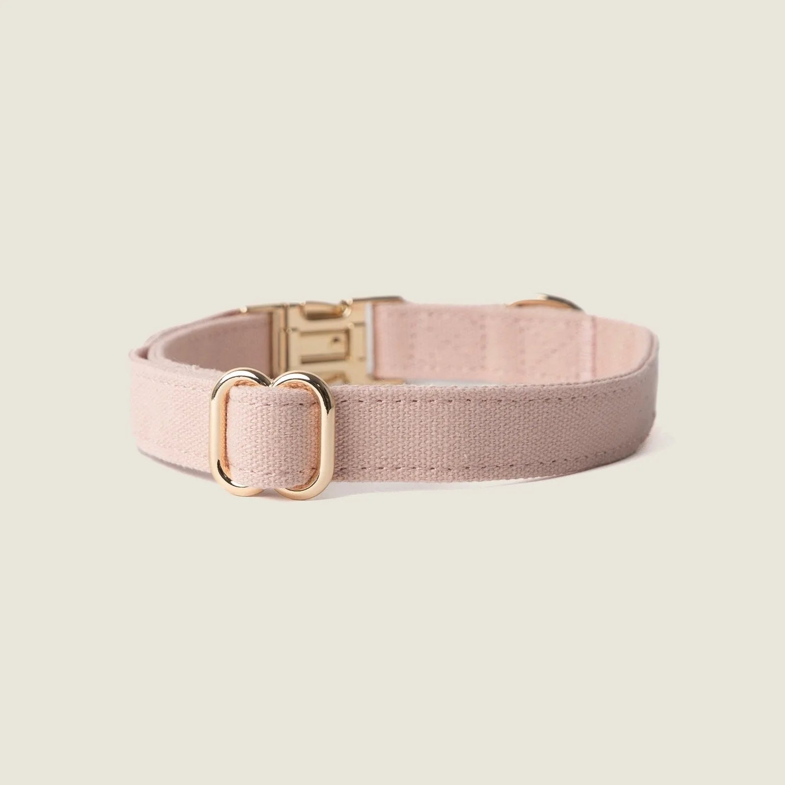 Soft baby pink canvas dog collar with gold hardware, showcasing a minimal design for comfort and style.