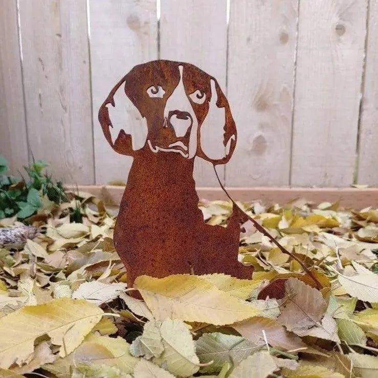 Rusty metal silhouette of a Beagle, seated among autumn leaves, perfect for outdoor dog decor.