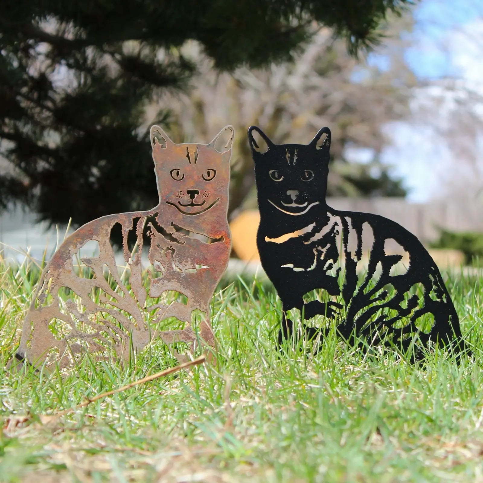 Handmade Bengal metal silhouettes in Corten steel and black finish, displayed together on grass outdoors.