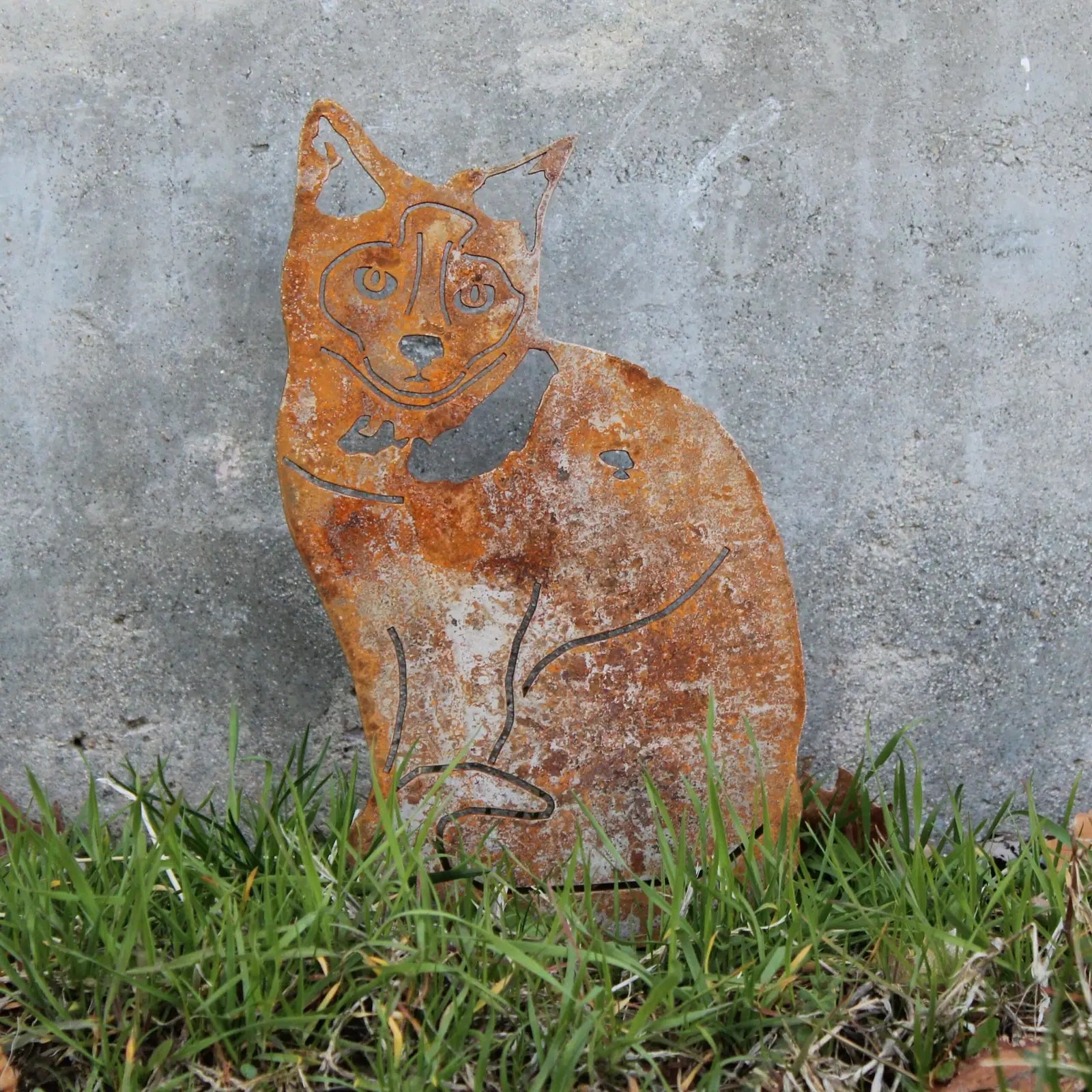 Rusty Corten steel silhouette of a Birman dog, featuring intricate details, displayed in grassy outdoor setting.