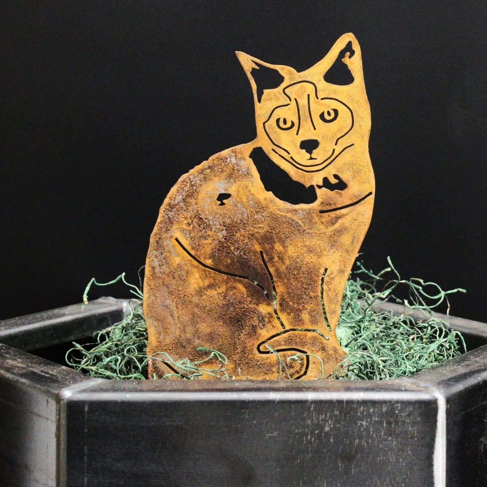 Rusty Corten steel Birman cat silhouette art piece, showcasing intricate cutouts, set in a planter with green moss.