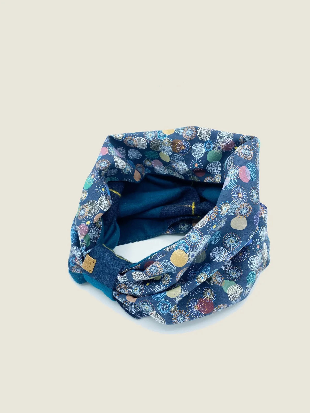 Reversible pet snood in blue with colorful round patterns, perfect for keeping dogs warm and stylish.