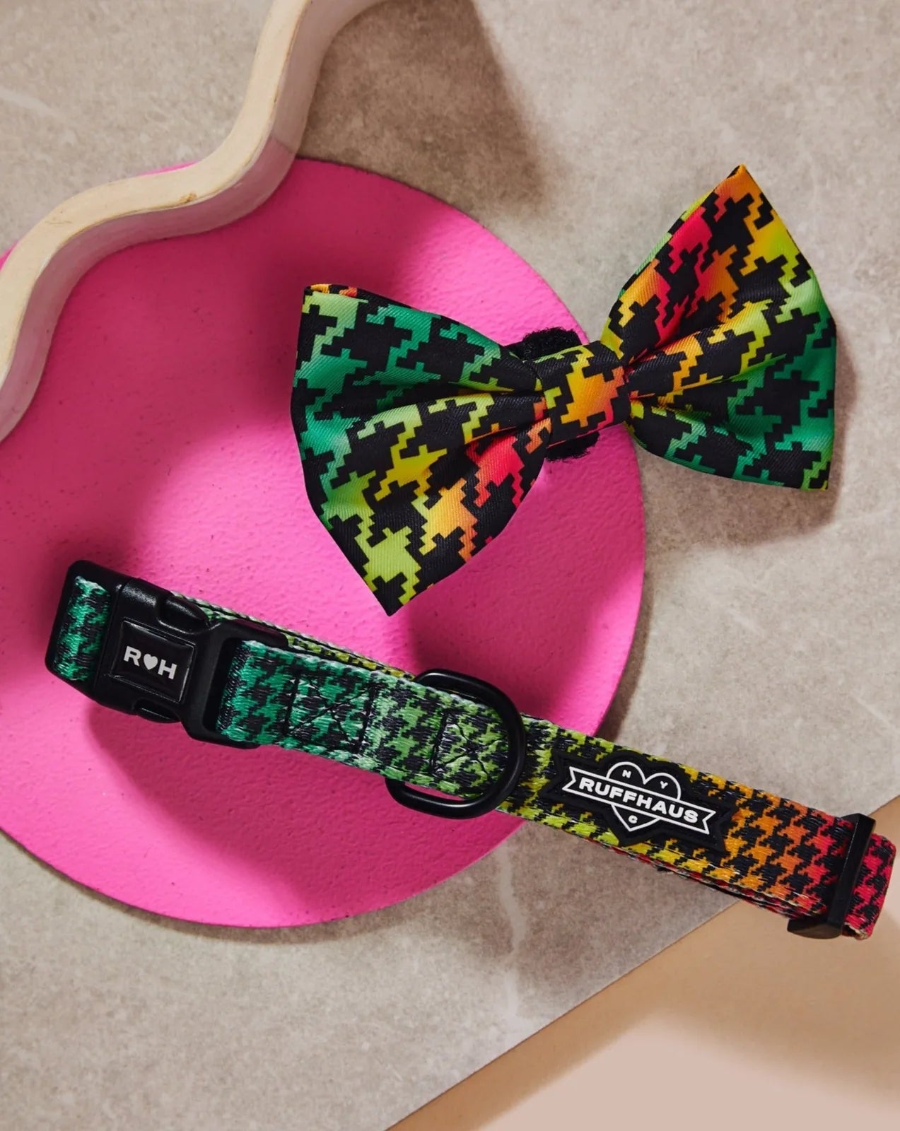 Colorful houndstooth pattern collar and matching bowtie, featuring durable material and adjustable design on a pink backgr...