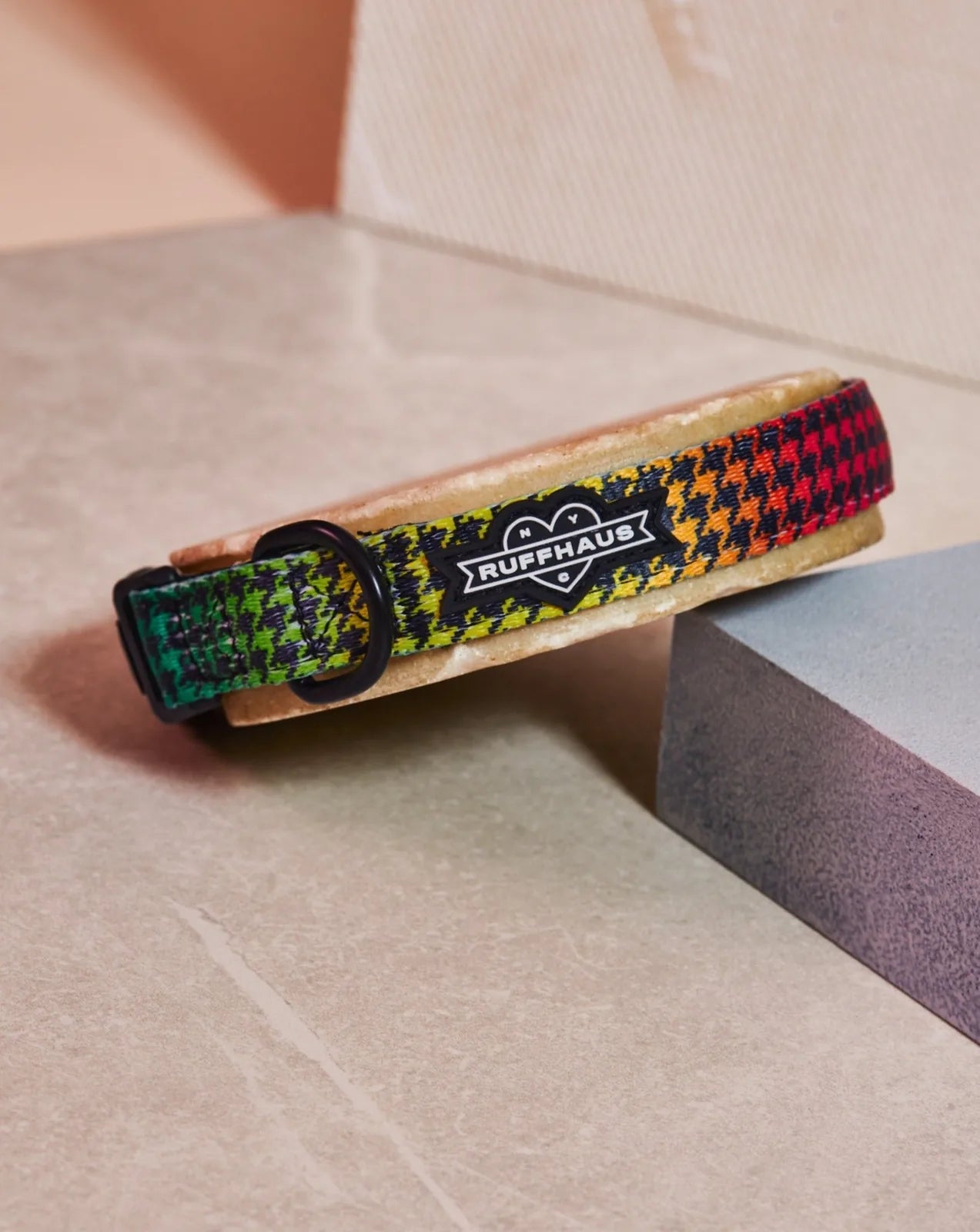 Adjustable dog collar featuring a vibrant houndstooth pattern in green, yellow, and red by RUFFHAUS NYC.