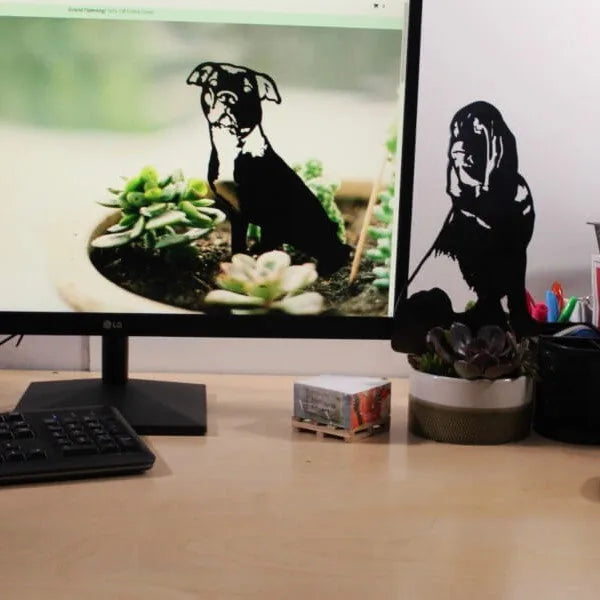 Black metal silhouette of a Bloodhound next to a potted succulent on a desk.