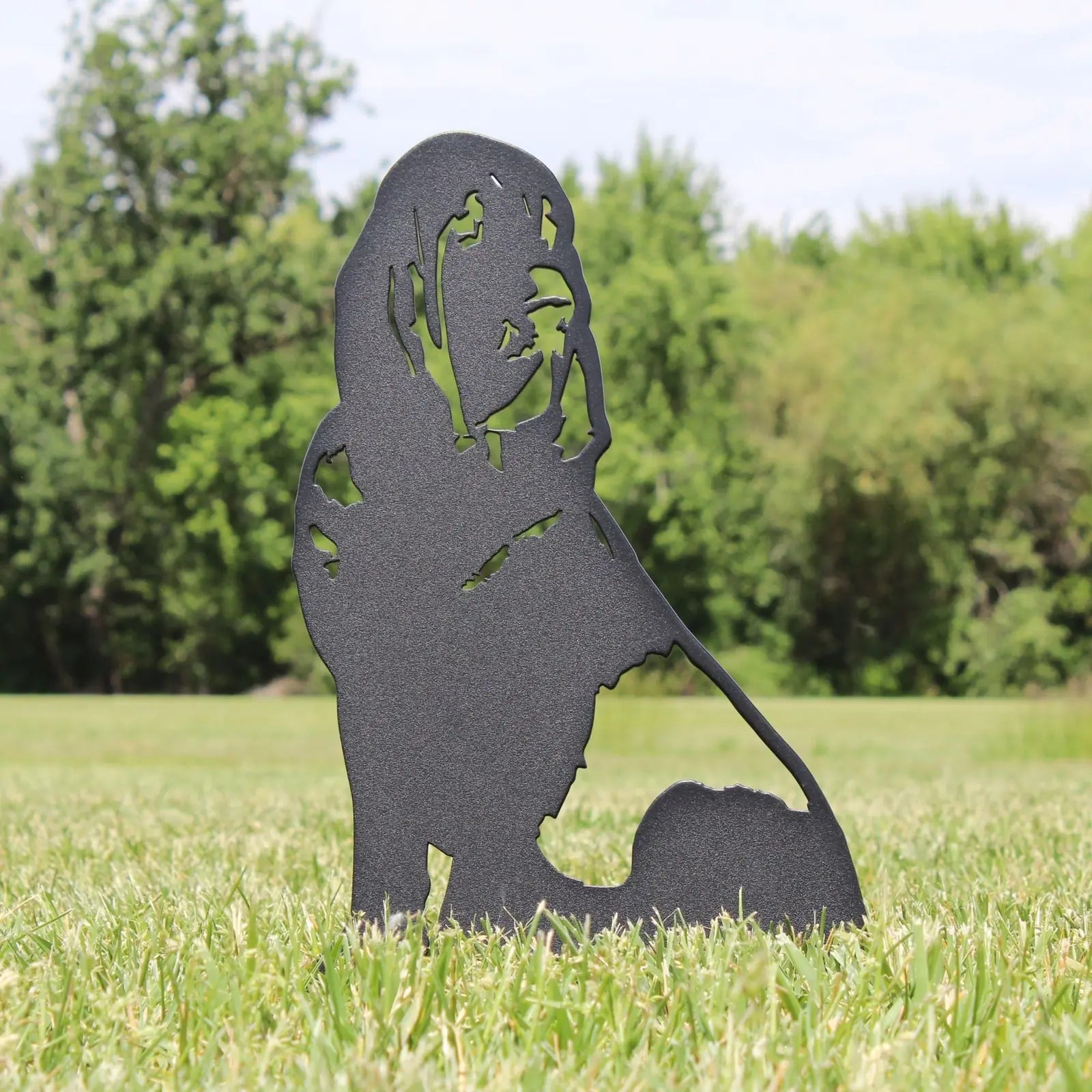 Black Bloodhound metal silhouette stand on grass, showcasing detailed cutouts against a natural green backdrop.