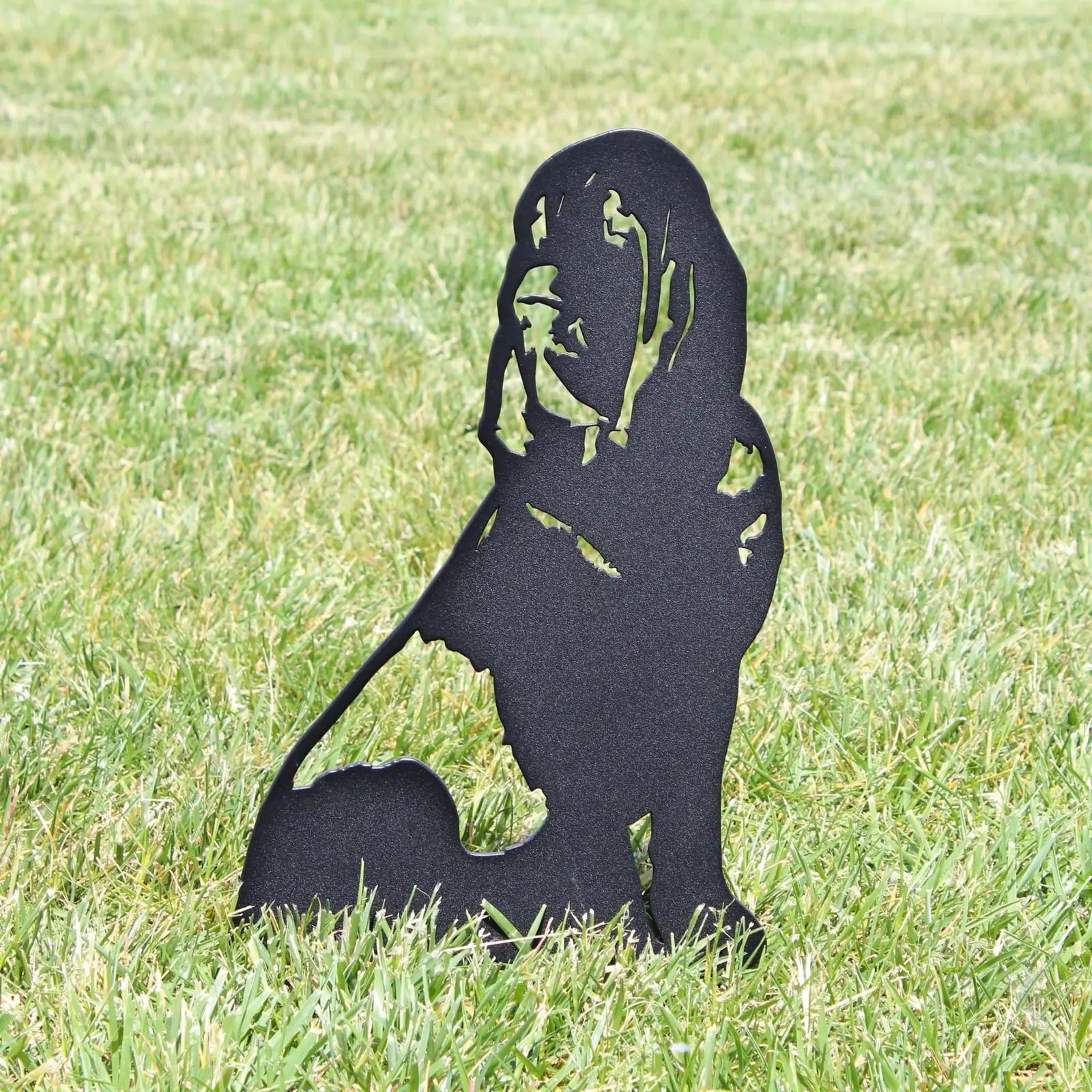 Bloodhound metal silhouette in matte black, standing on grass, showcasing intricate cutouts and outdoor decor design.