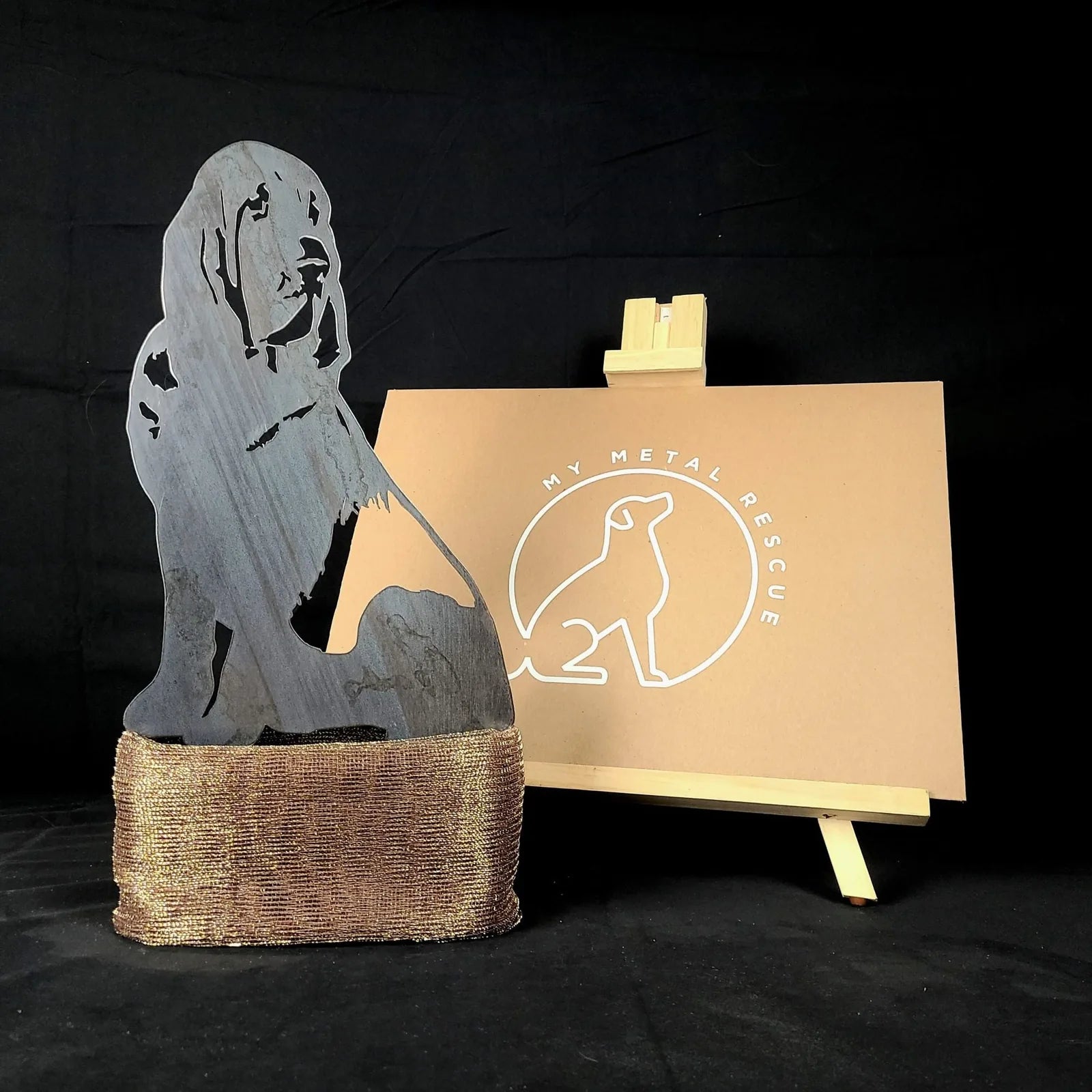 Bloodhound metal silhouette crafted from Corten steel, displayed on a textured base with a branded background.