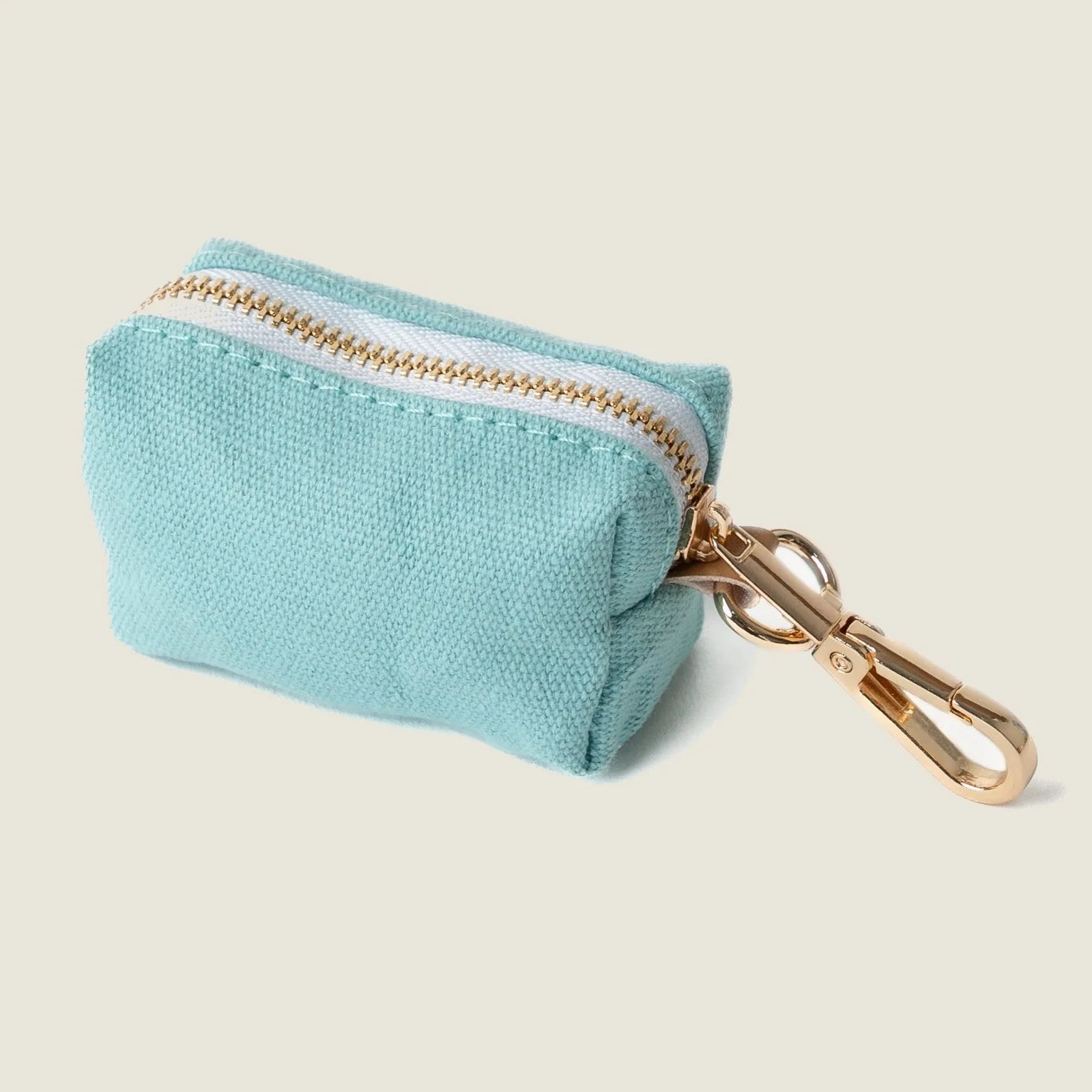 Light blue fabric poop bag holder with gold zipper and clip for easy attachment to a leash.
