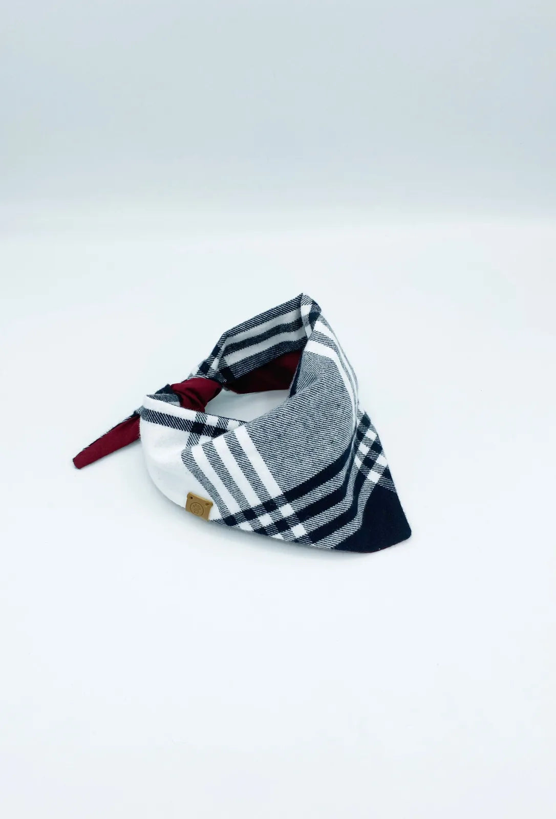 Reversible pet bandana in black, white, and burgundy plaid, made of soft cotton flannel for comfort.
