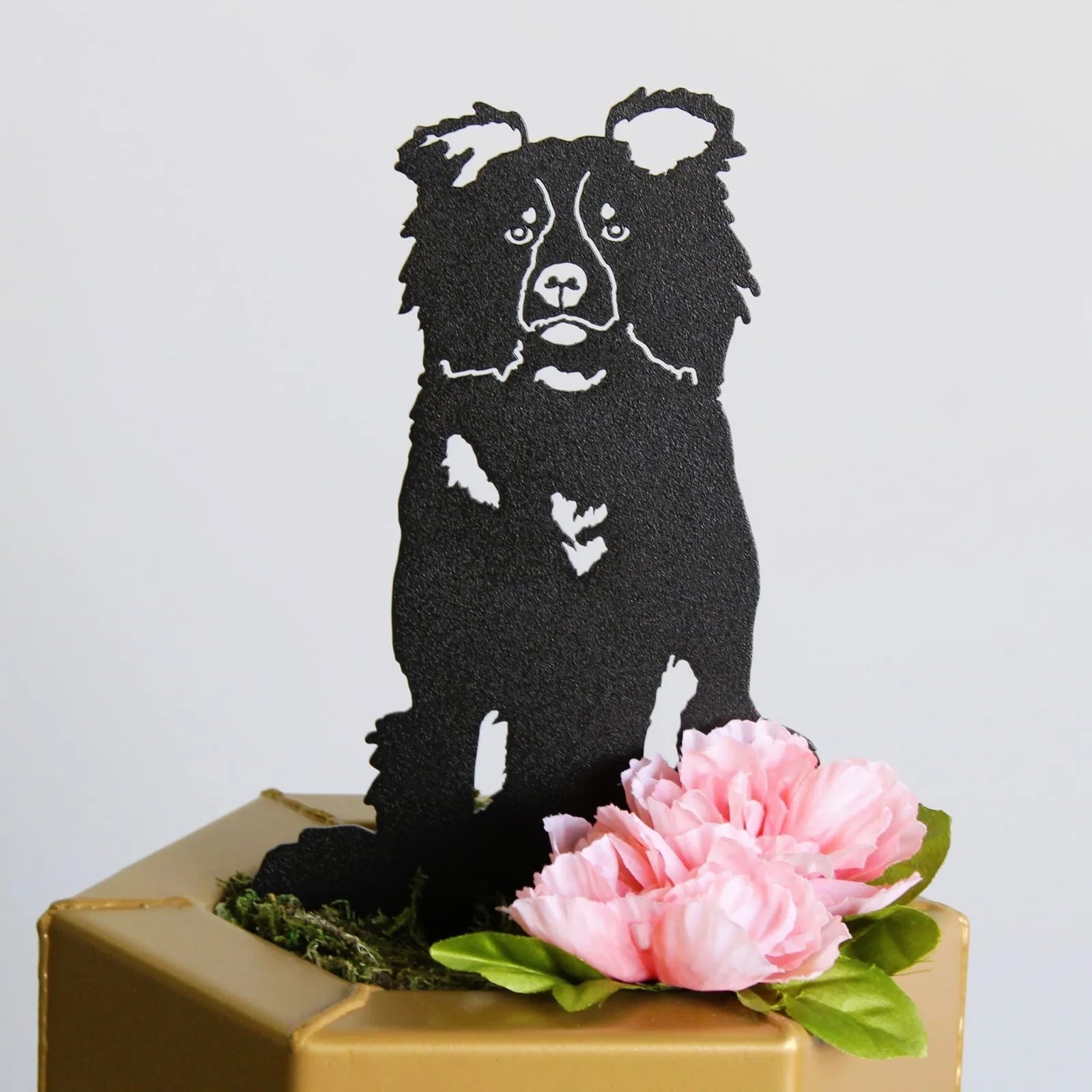 Black metal silhouette of a Border Collie, featuring a detailed design against a light background, adorned with pink flowers.