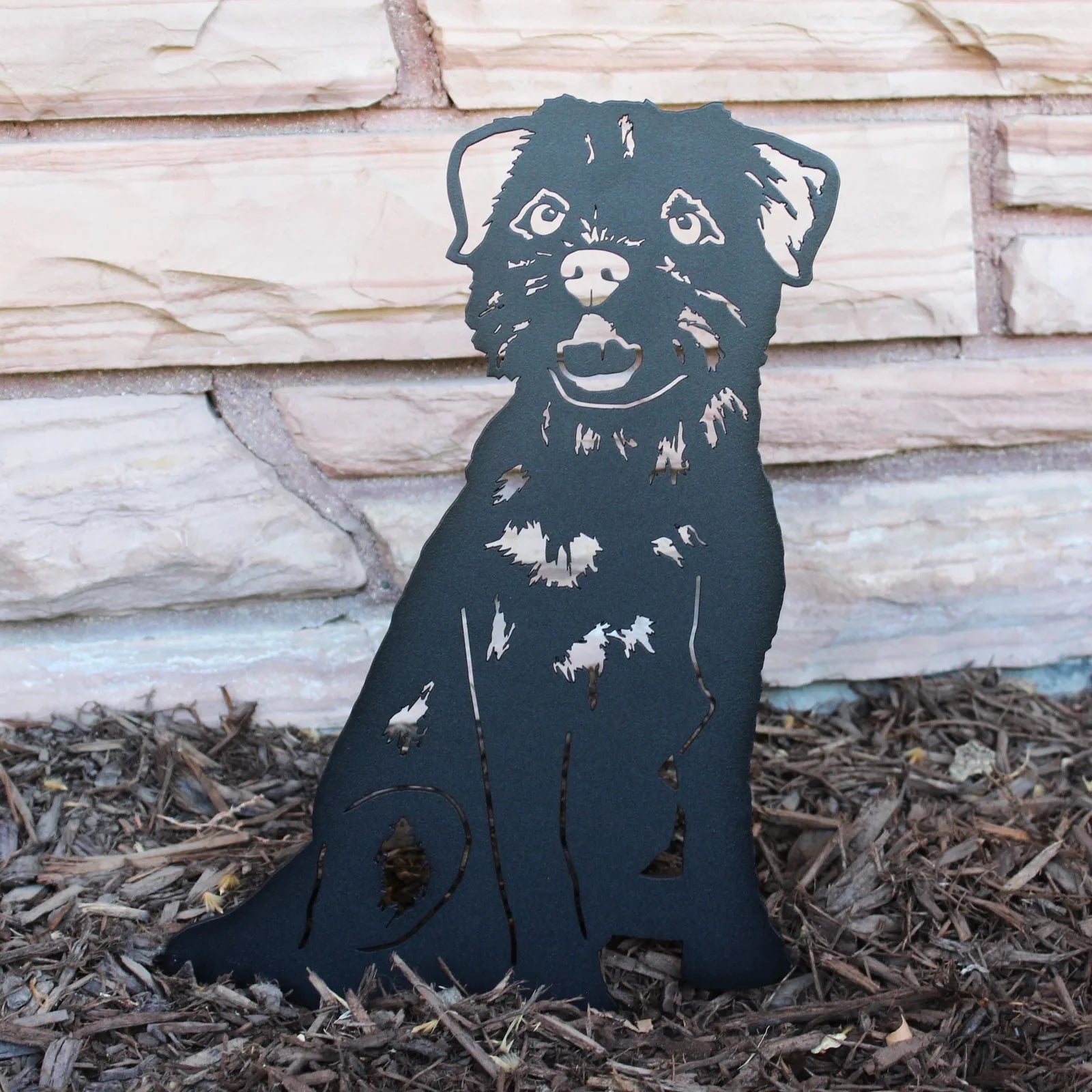 Border Terrier silhouette in matte black metal, displayed on mulch, showcasing detailed cutout design and sturdy construct...
