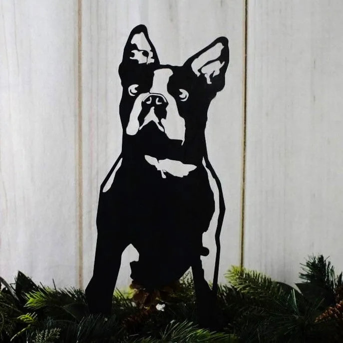 Black metal silhouette of a Boston Terrier against a light wooden background, ideal for outdoor dog decor.