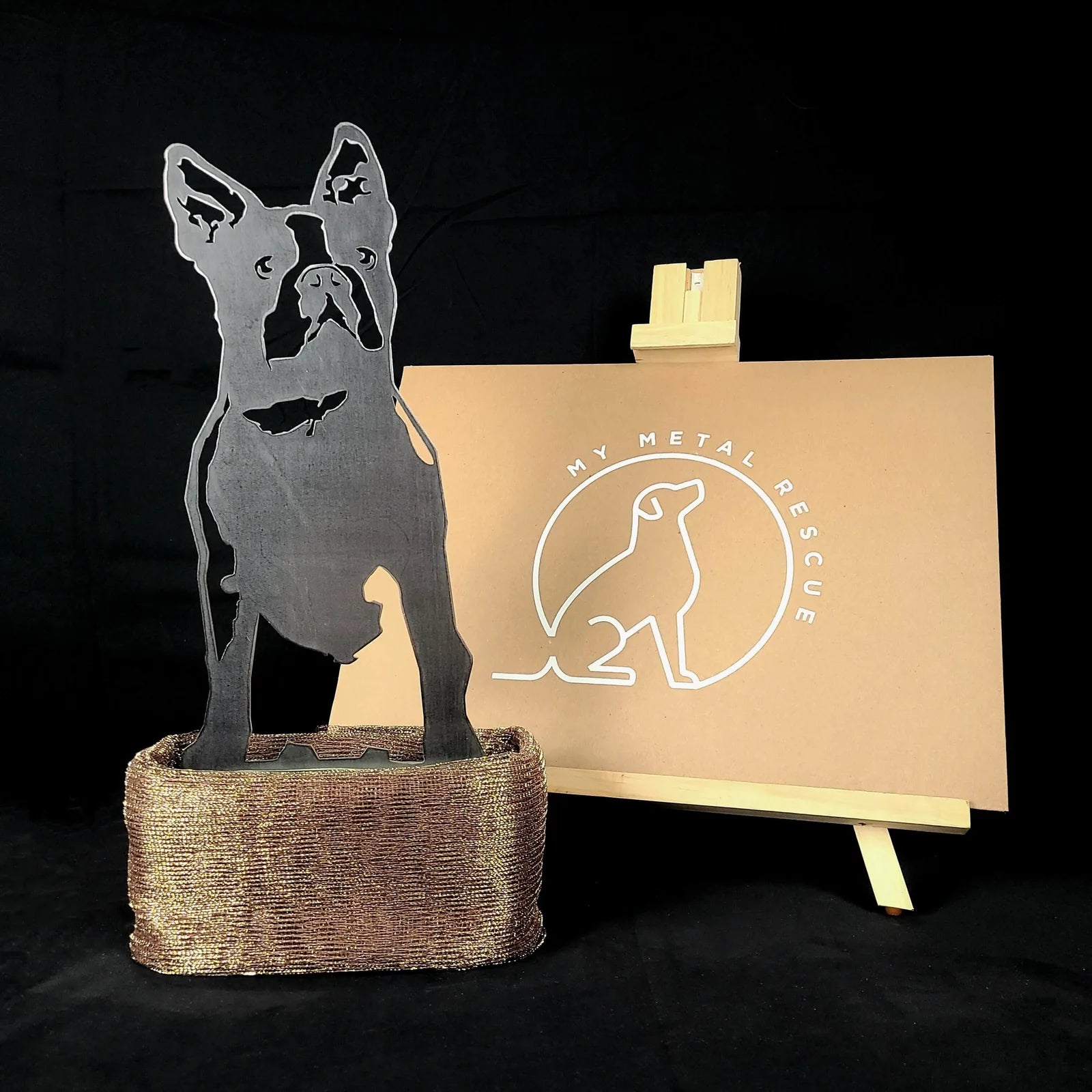 Boston Terrier metal silhouette standing on a decorative base, showcasing its sleek design against a neutral background.
