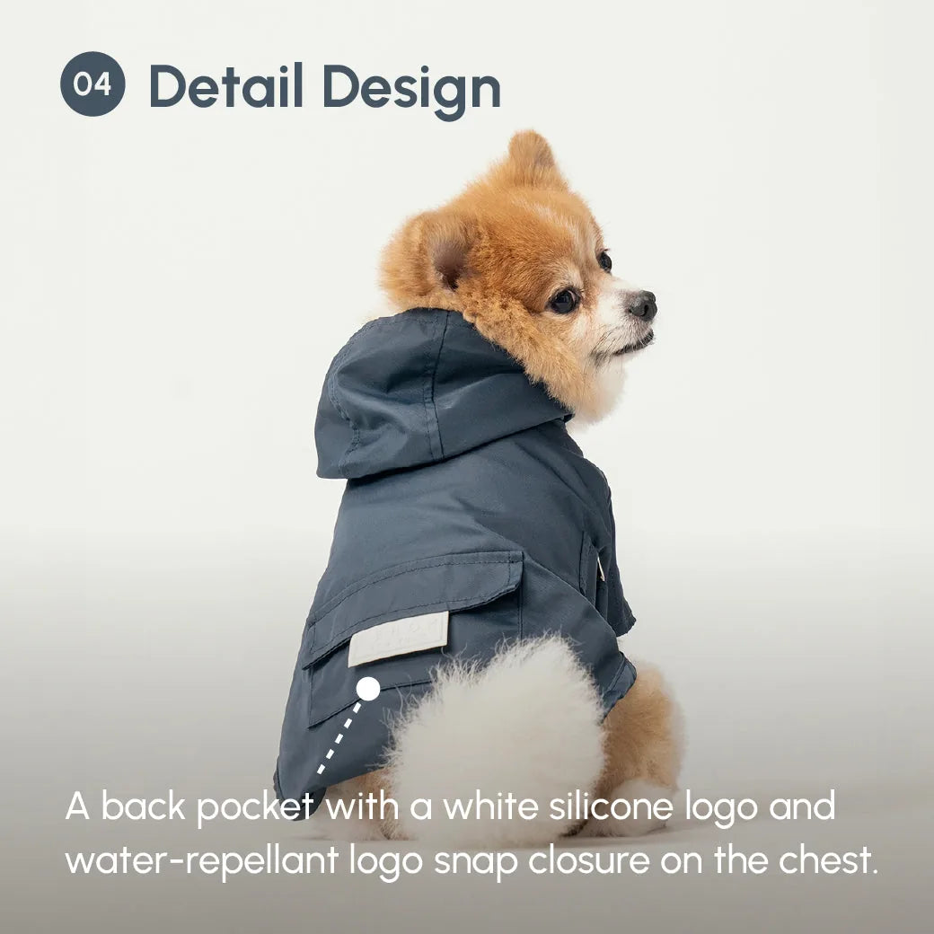 Blue Bowery raincoat on a dog, featuring a back pocket with a white silicone logo and a water-repellant snap closure.
