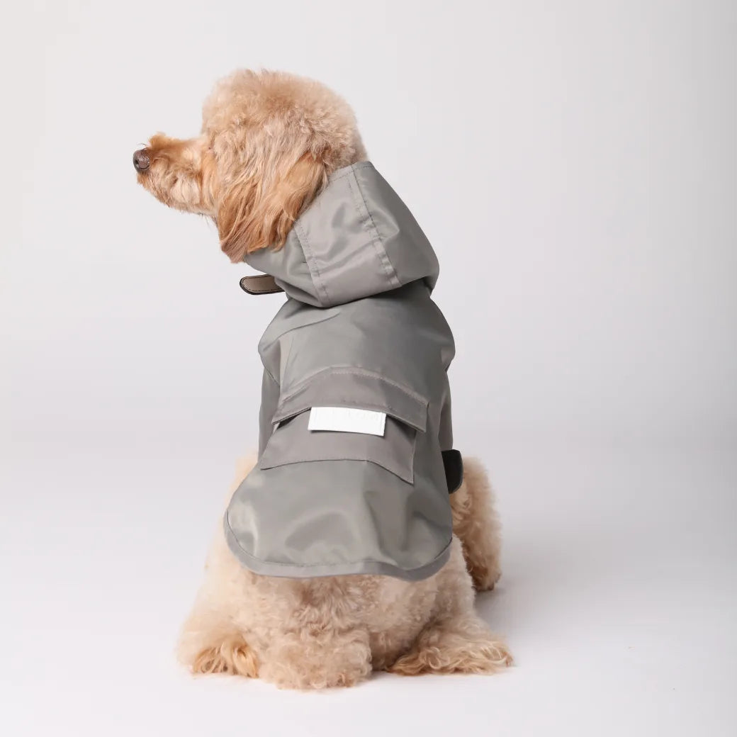 Gray water-repellent dog raincoat with a hood, adjustable Velcro, and pockets, designed for comfort and style.