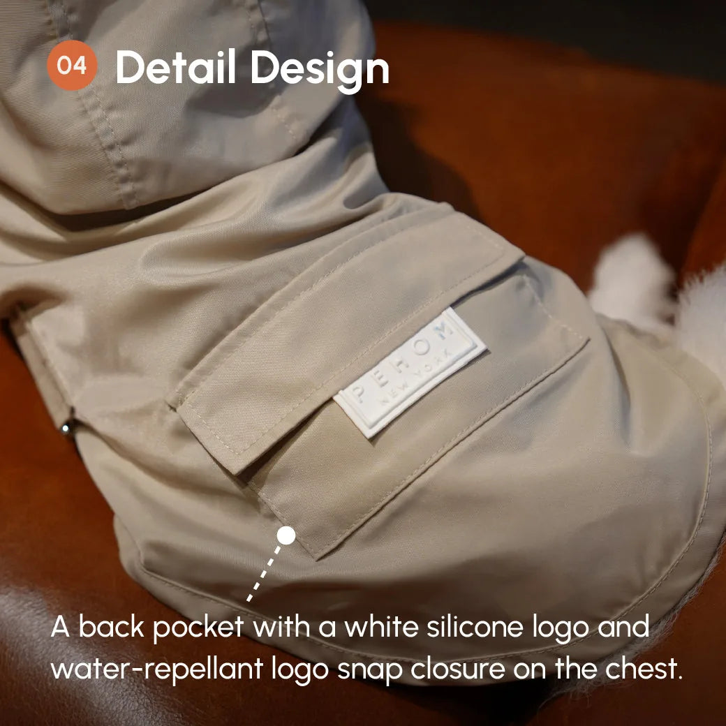 Close-up of a tan dog raincoat featuring a white silicone logo pocket and a water-repellent snap closure.