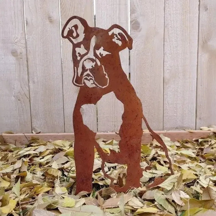 Rust-colored metal boxer dog silhouette standing on a bed of leaves, perfect for outdoor dog decor.