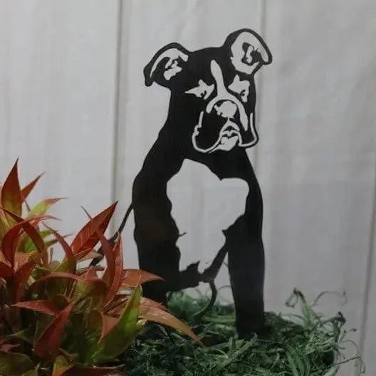 Black metal Boxer silhouette statue set among greenery, perfect for outdoor dog decor. Handmade in the USA.