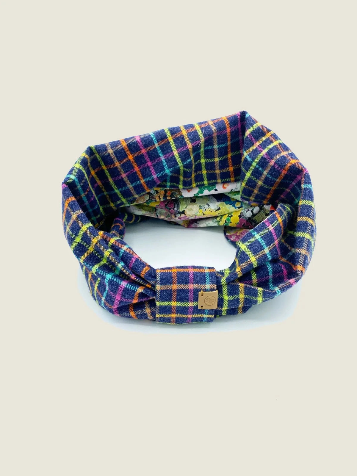 Reversible dog snood featuring colorful plaid on one side and a floral print inside, made from soft brushed cotton flannel.