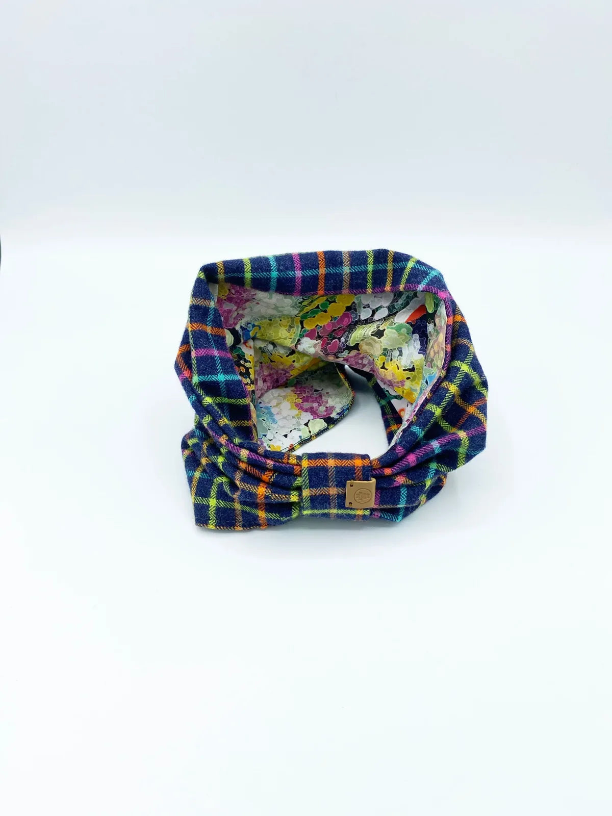 Reversible pet snood in vibrant black and white plaid with a colorful floral interior, made of soft brushed cotton flannel.
