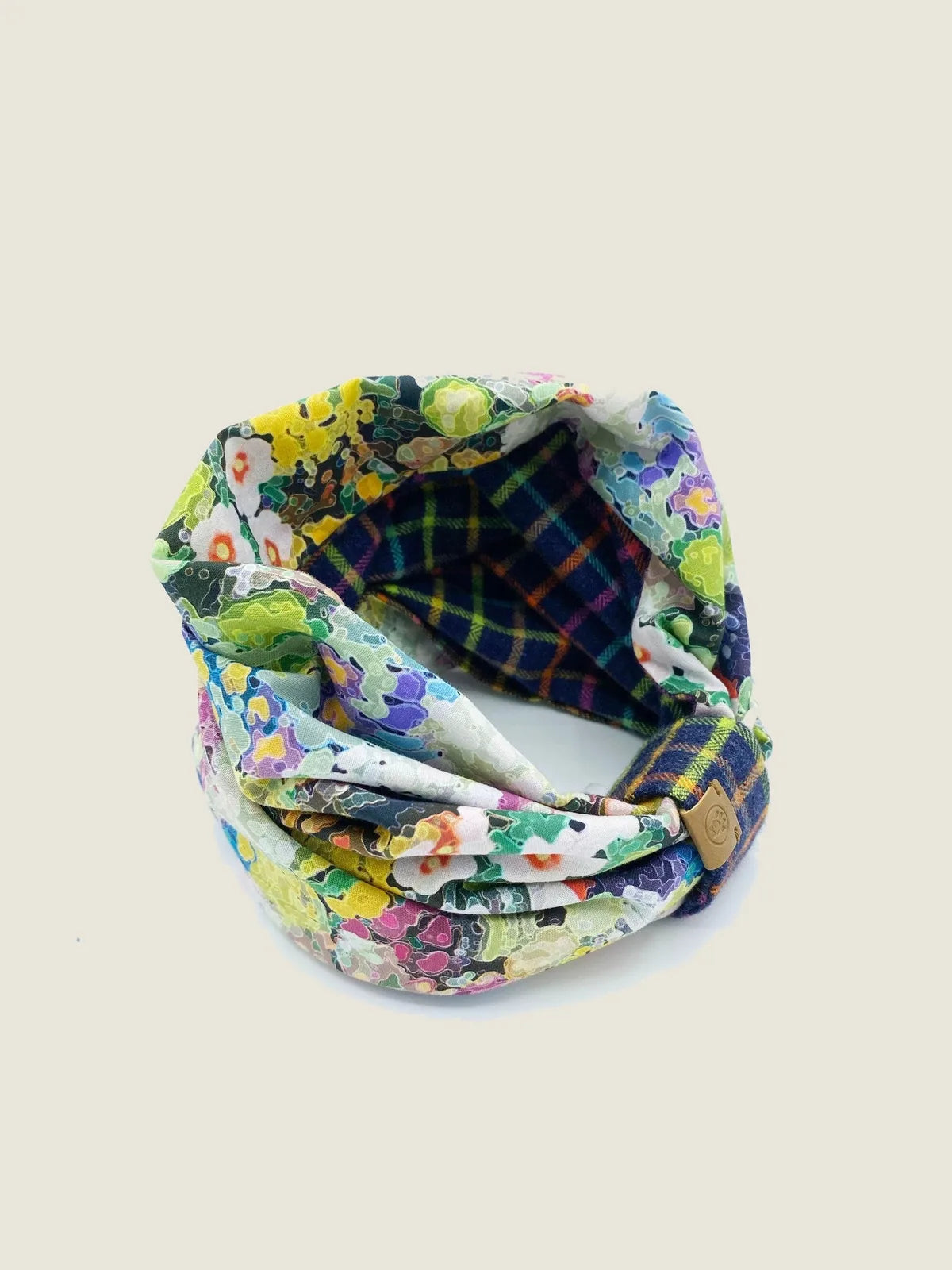 Reversible pet snood featuring black and white windowpane plaid and vibrant rainbow floral prints, made of soft cotton fla...