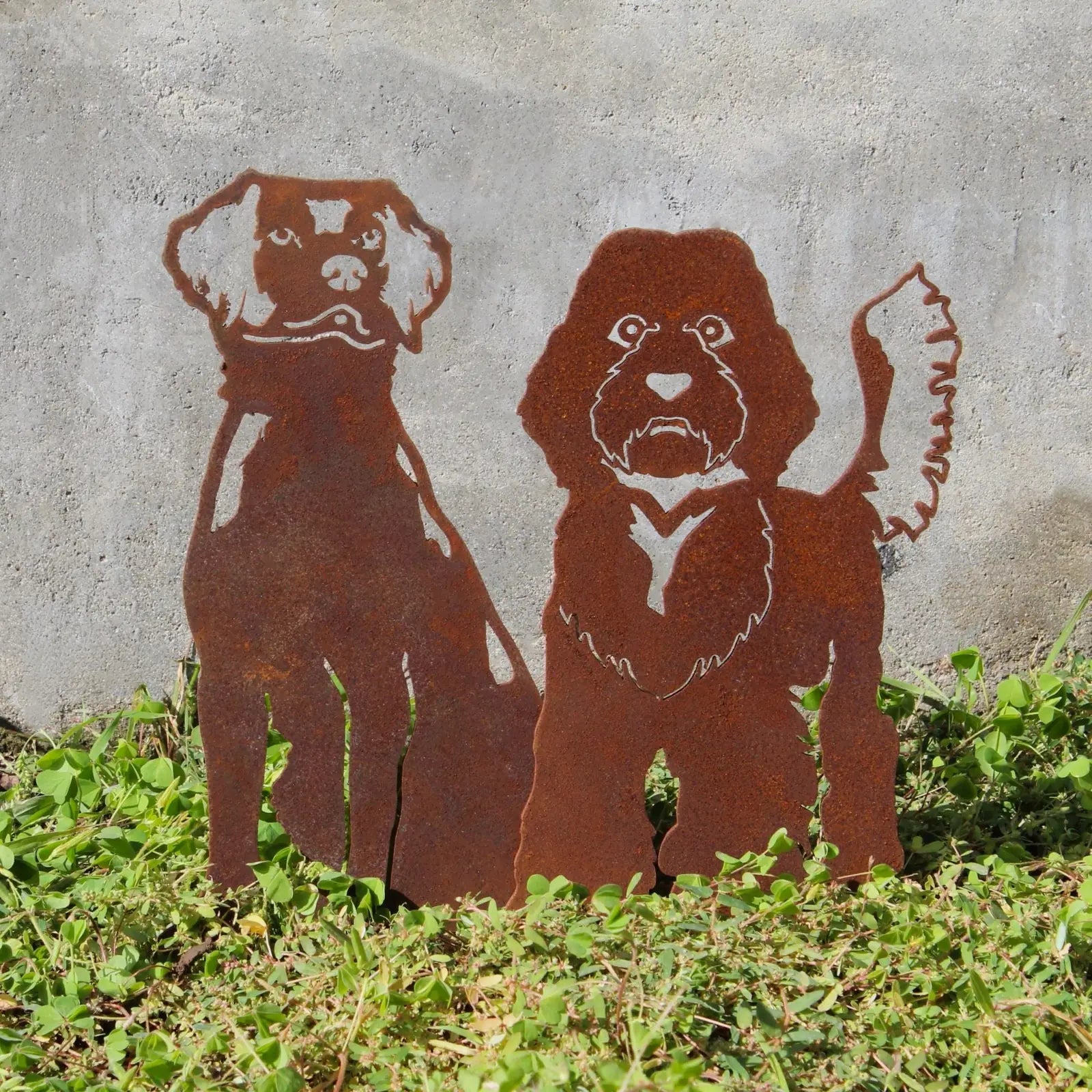 Rusty metal silhouette of two dogs in a garden, showcasing a Brittany Spaniel and a mixed breed design.