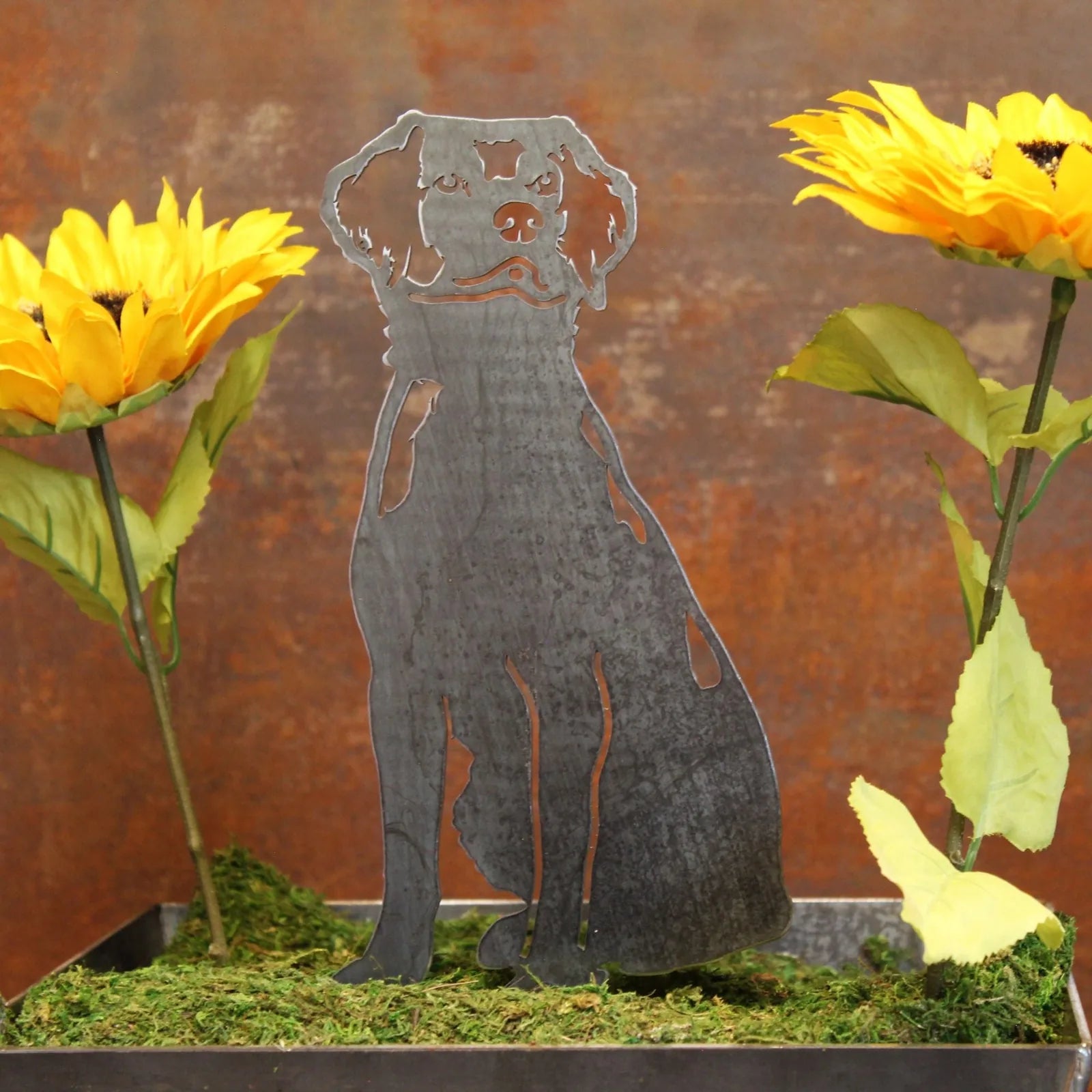 Metal silhouette of a Brittany Spaniel sits among vibrant sunflowers, showcasing Corten steel craftsmanship and outdoor de...