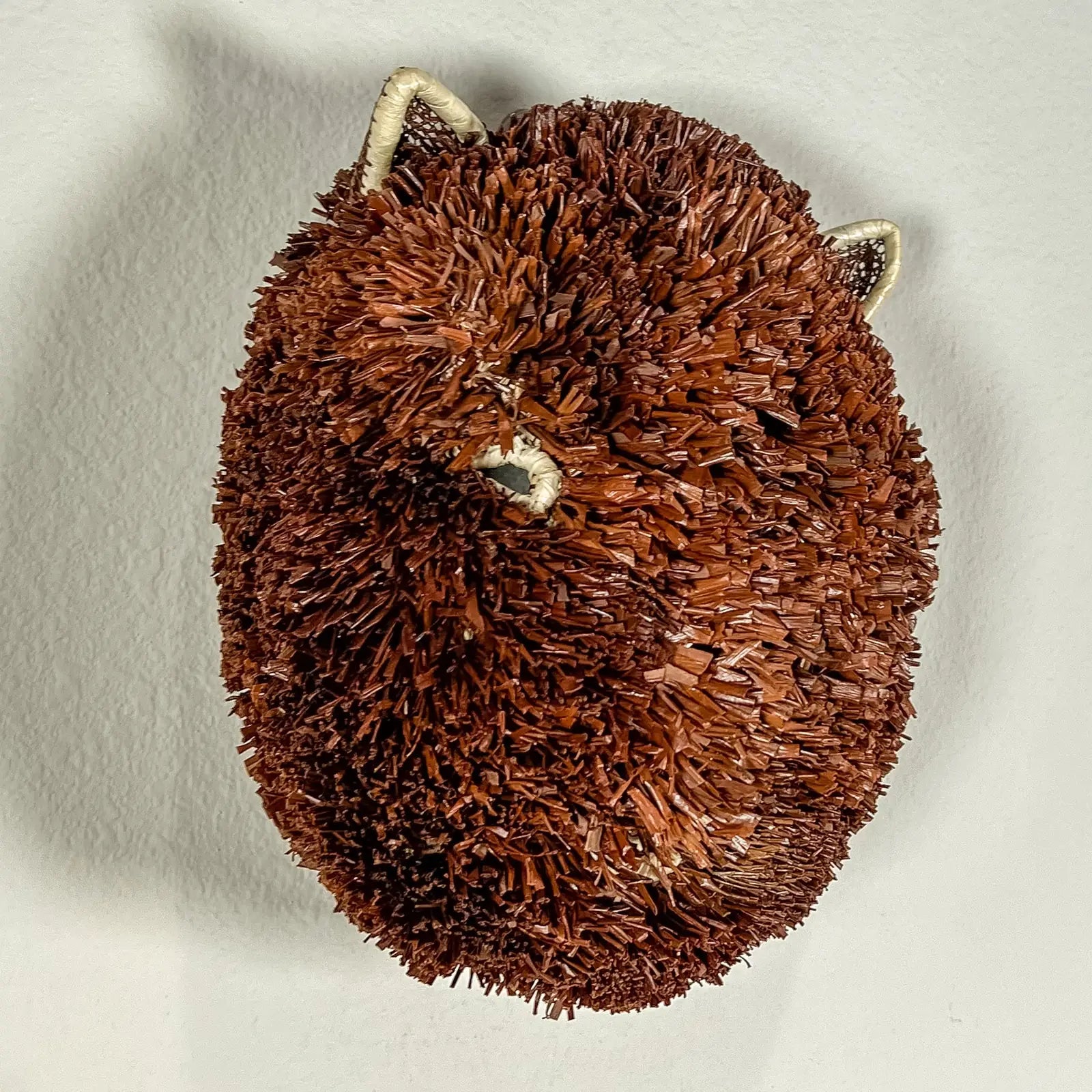 Handwoven brown and white Labradoodle mask featuring natural textures, ideal for artistic wall decor.