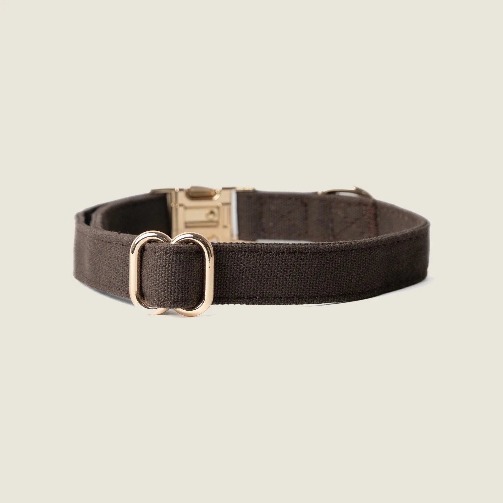 Dark brown canvas dog collar with gold hardware, designed for comfort and style, ideal for daily wear.
