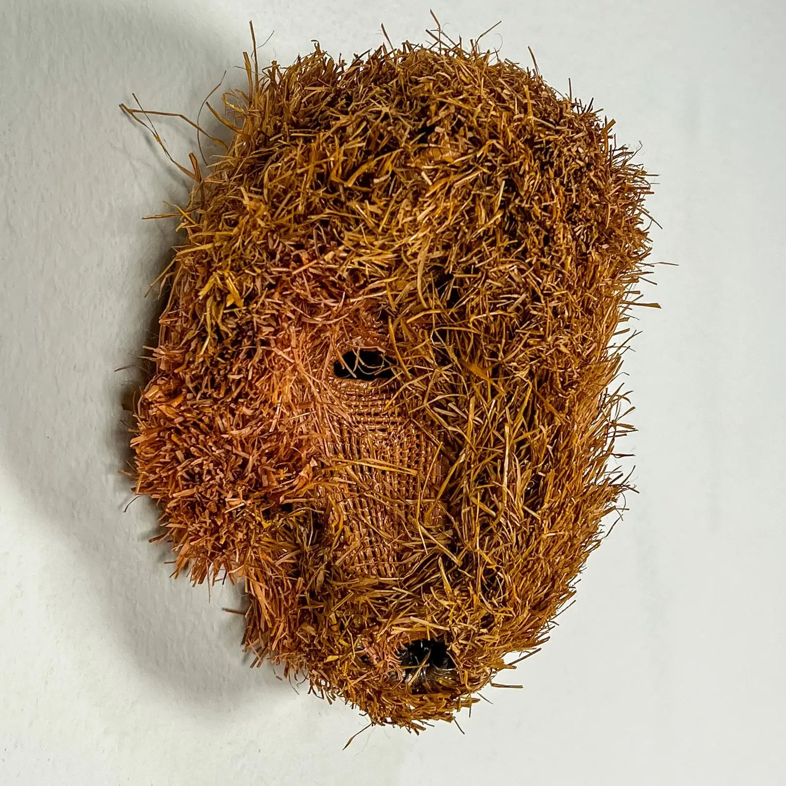 Handwoven Brown Labradoodle mask in earthy tones, highlighting intricate patterns made with natural materials.