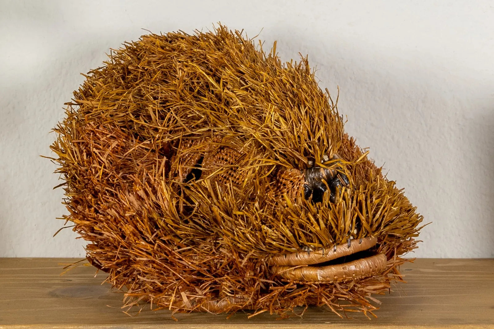 Handwoven brown Labradoodle mask made of natural fibers, showcasing intricate textures and warm earthy tones.