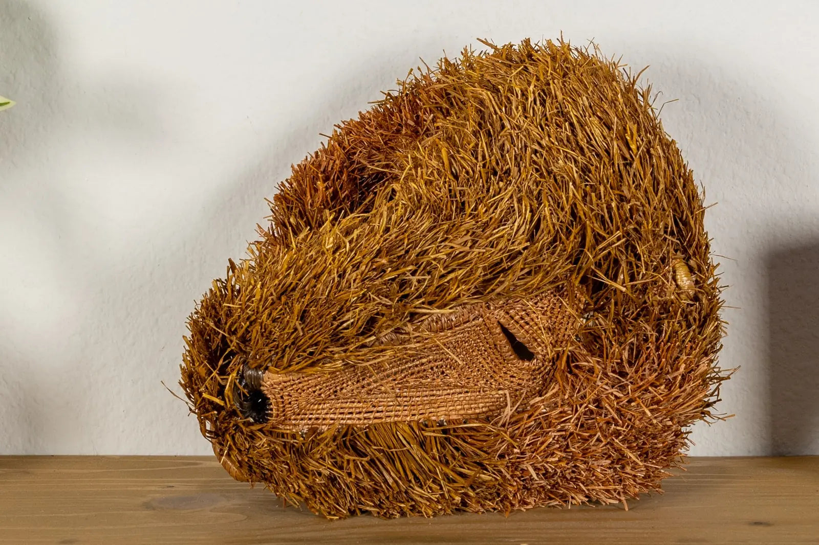 Handwoven brown Labradoodle dog mask, crafted from natural materials, featuring intricate patterns and a unique shape.